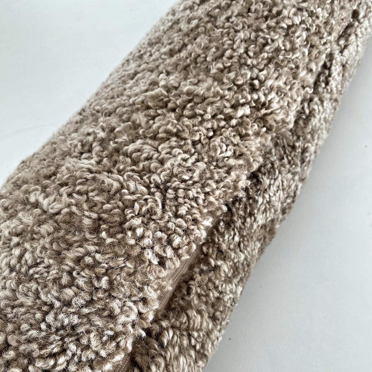 Introduce charming textures to your decor with this pure wool boucle lumbar pillow. The boucle pillow is made from a short curly wool sheepskin that will bring any piece of furniture to life. Translating contemporary design paralleled with comfort