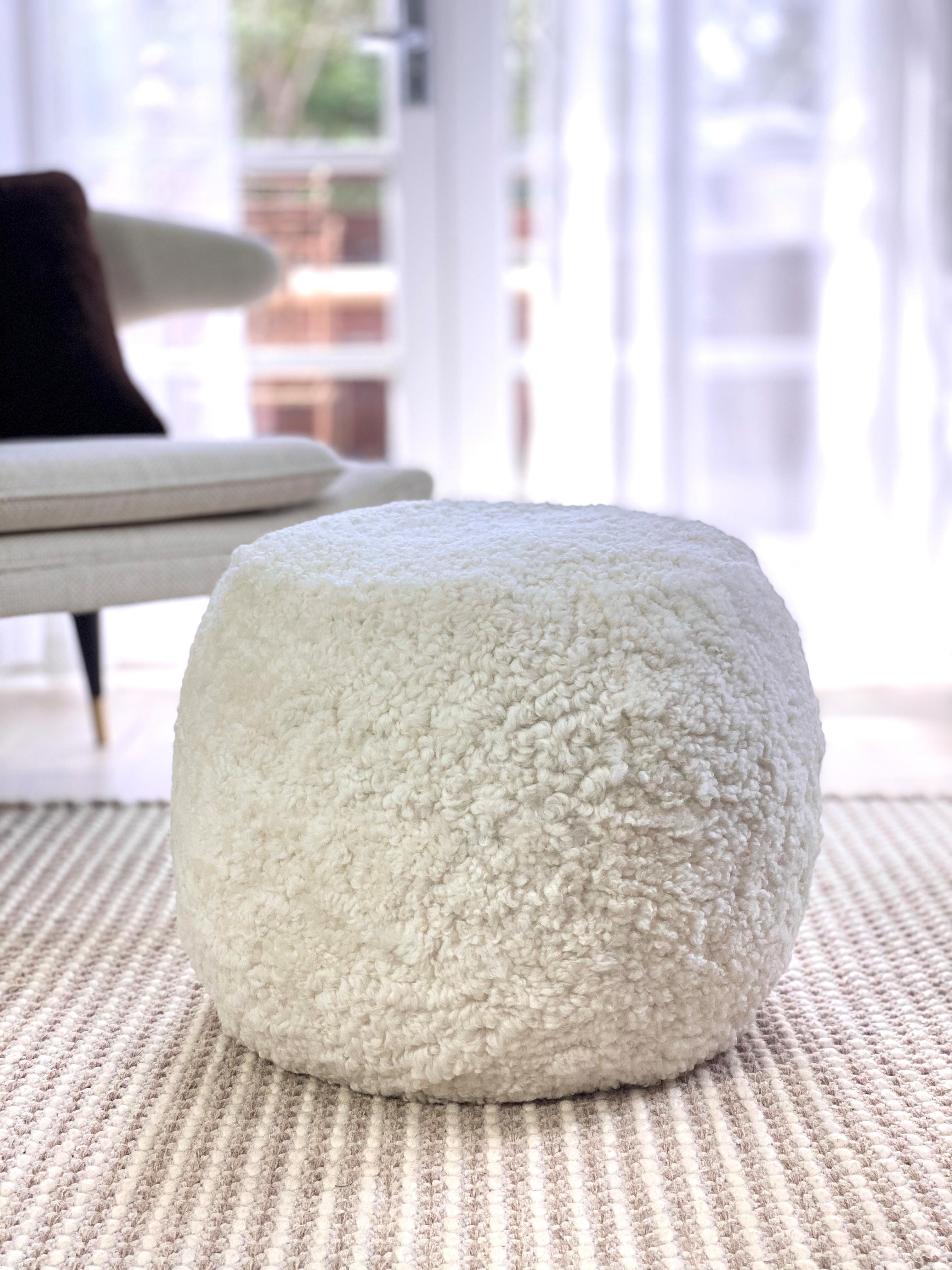 This strikingly elegant round boucle ottoman enhances the contemporary mood of an interior. Crafted from exquisite short curly wool, shearling sheepskin providing soft and natural textures to a space. 
Designed and made in Australia, the natural