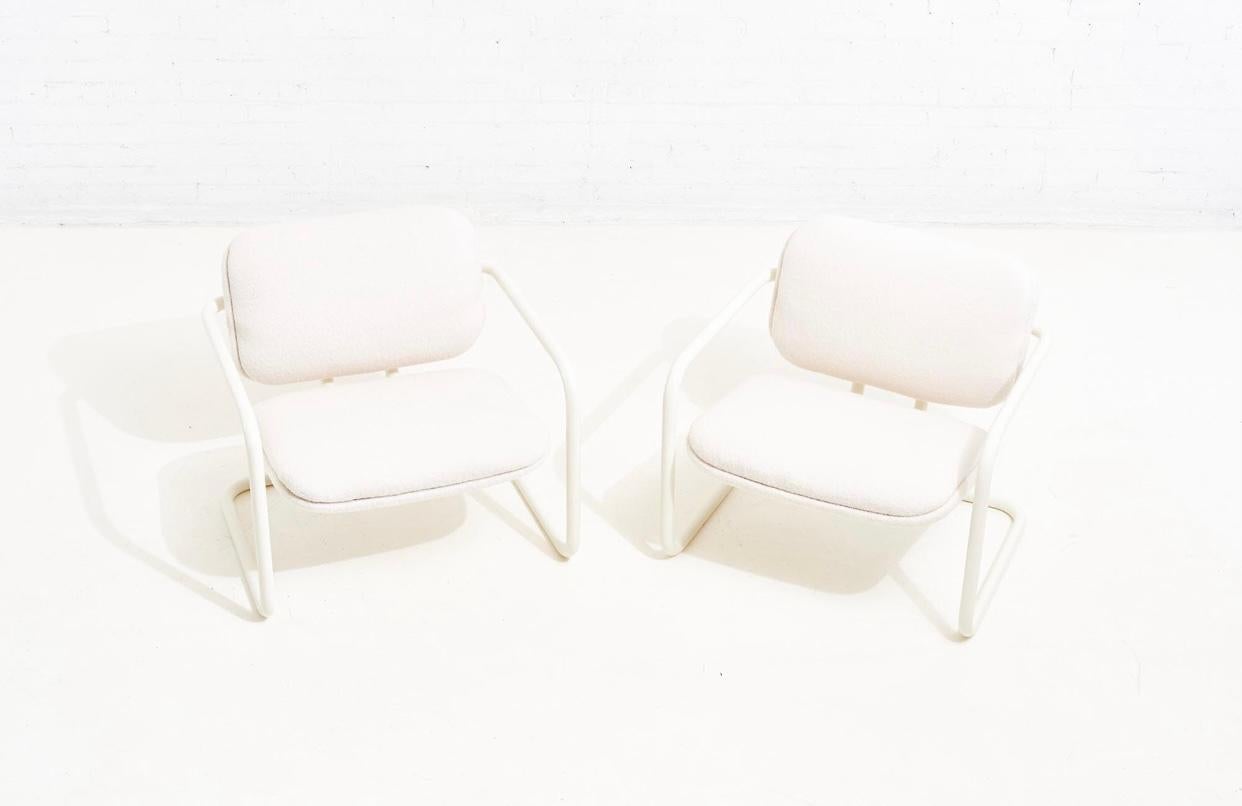 Boucle Post Modern tubular lounge chairs, 1970. The seat cantilevers out from the back floating from the frame. Newly reupholstered in white boucle and restored.