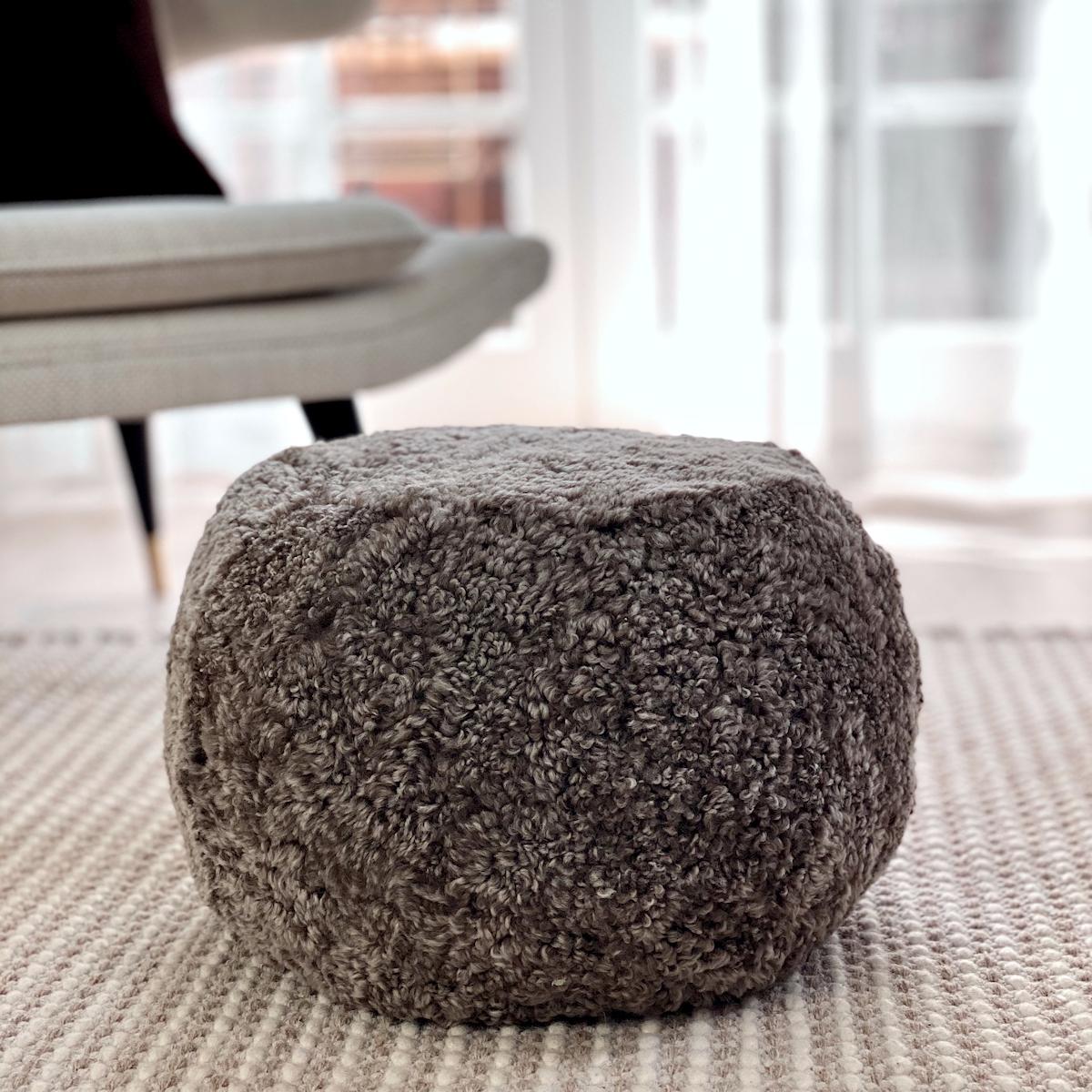 This strikingly elegant boucle pouf will enhance the contemporary mood of any interior. Hand-crafted from exquisite short curly wool, shearling sheepskin provides intimate soft natural textures of comfort and luxury. 
Designed and made in