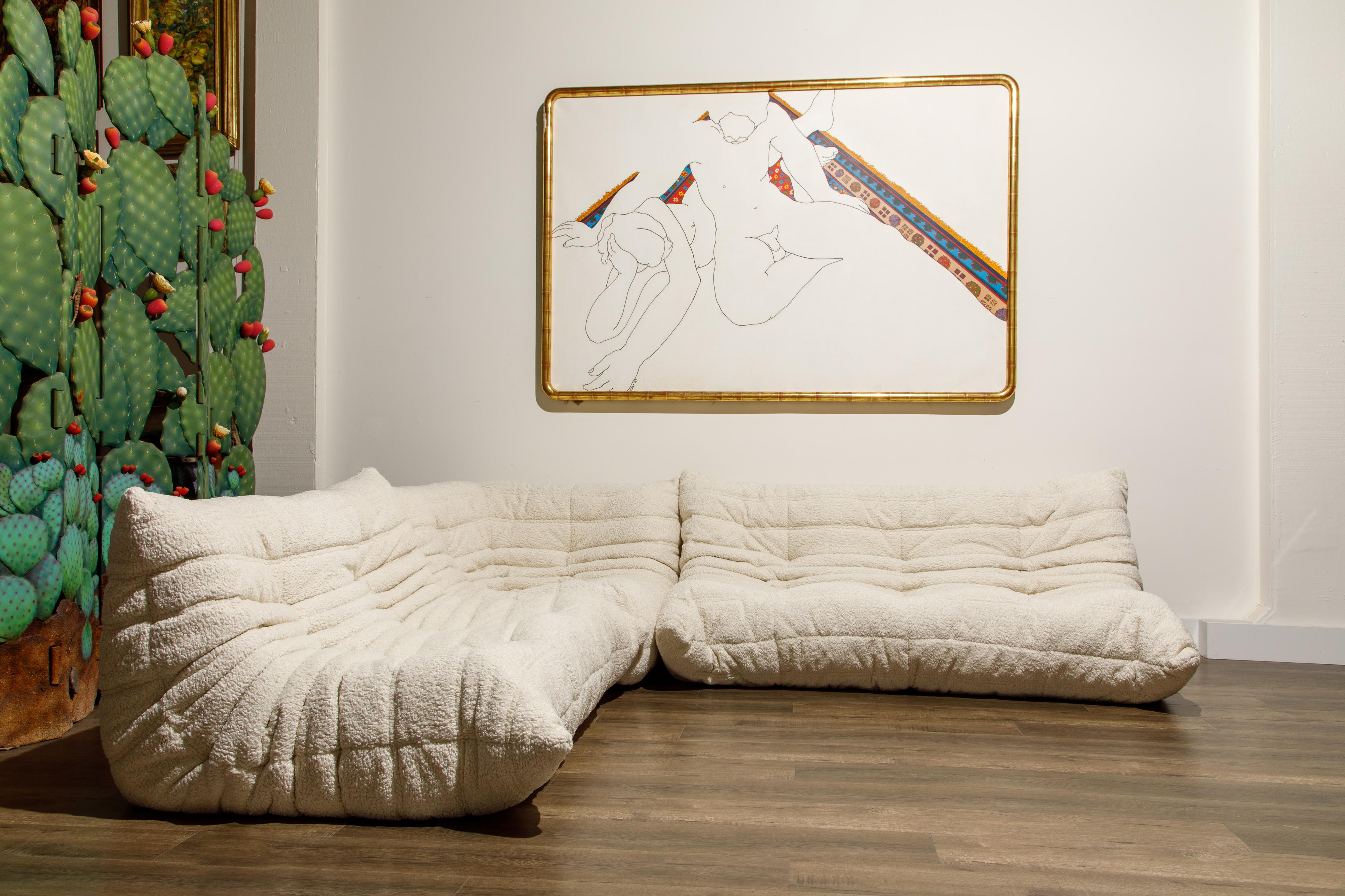 This incredible, newly reupholstered in white bouclé fabric, three-piece 'Togo' sectional living room set, was designed by Michel Ducaroy in 1973 for Ligne Roset, France. This set is comprised of a three-seat couch, two-seat loveseat and corner seat