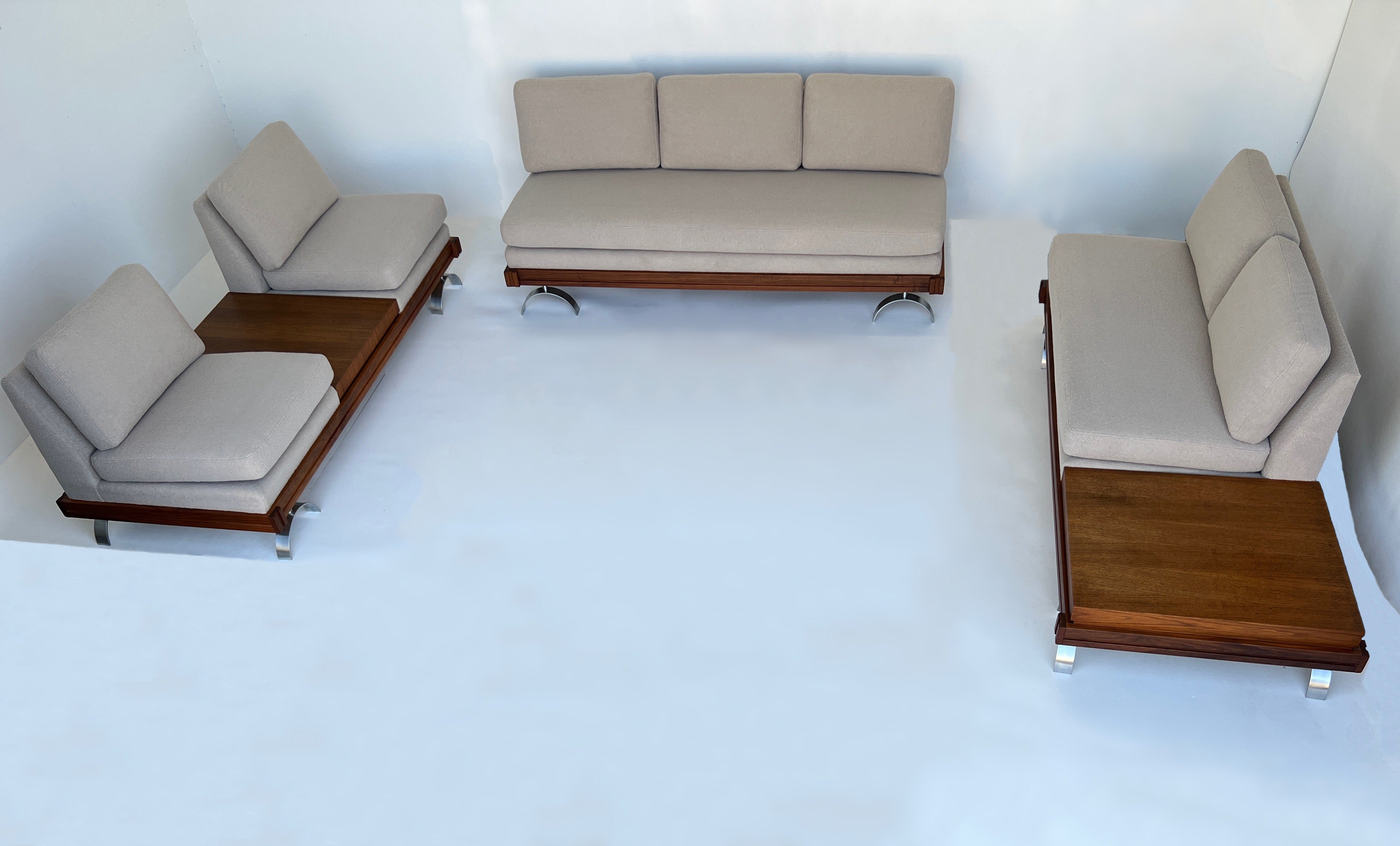 Spectacular three piece sectional sofa set designed in the 1950’s by Martin Borenstein. 
Constructed of walnut frame, stainless steel legs and newly upholstered with a soft off white boucle fabric. 
The frame is in original condition, shows minor