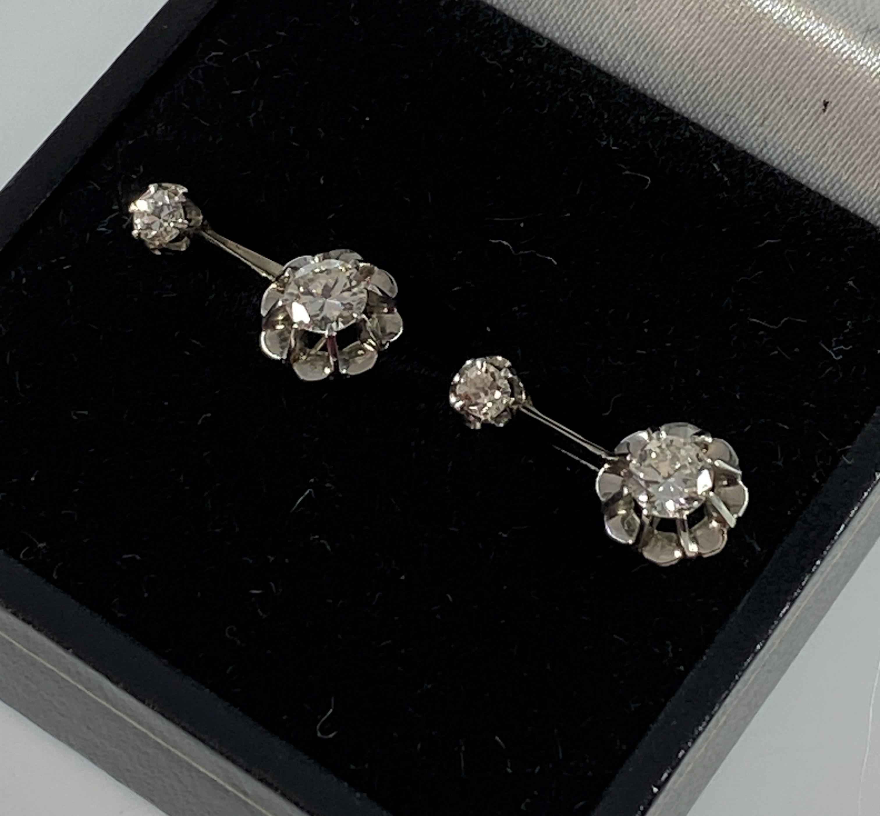 Charmante paire de boucles d’oreilles en or 18 carats et platine dites “ dormeuses ”, chacune sertie d’un diamant pesant environ 0.05/0.07 carat et d’un diamant pesant environ 0.25 carat. Le plus petit est fixe et en serti griffes, il soutient en