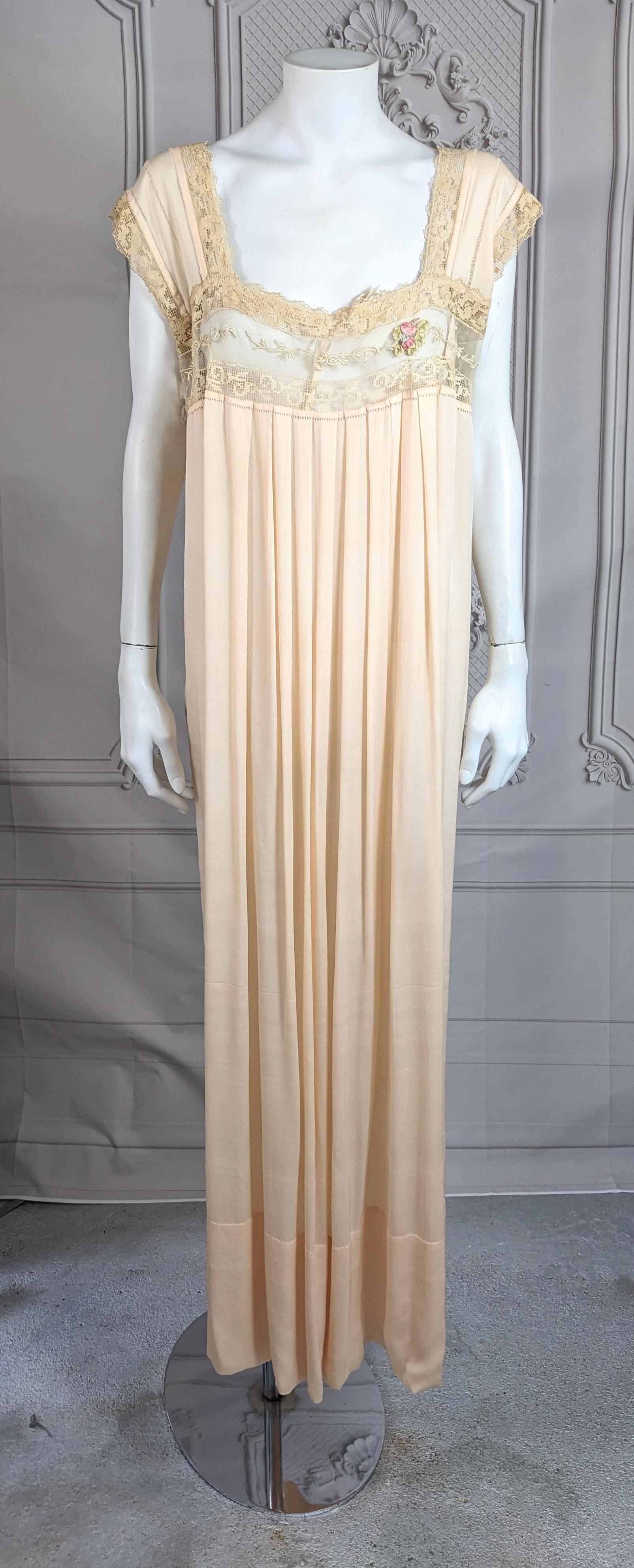 French Boue Soeurs style romantic 1920's  silk and lace gown. Composed of pale pink silk jersey crepe , the empire bodice of hand embroidered cotton tulle in floral motifs and fillet lace.  With signature Boue Soeurs hand made silk ribbon flower