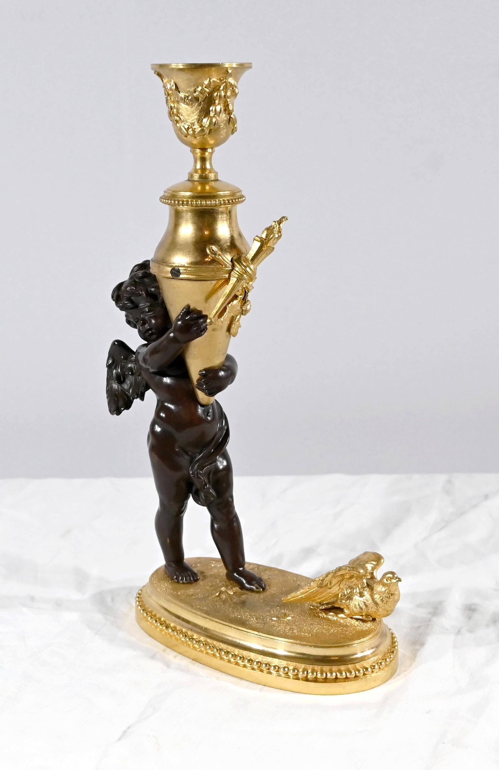 Incantevole candeliere in bronzo dorato e patinato firmato Ferville-Suan. Raffigura un cherubino che trasporta un'Amphora che forma un portacandele in bronzo dorato finemente cesellato. L'angelo paffuto è alato e indossa una benda. È un'allegoria