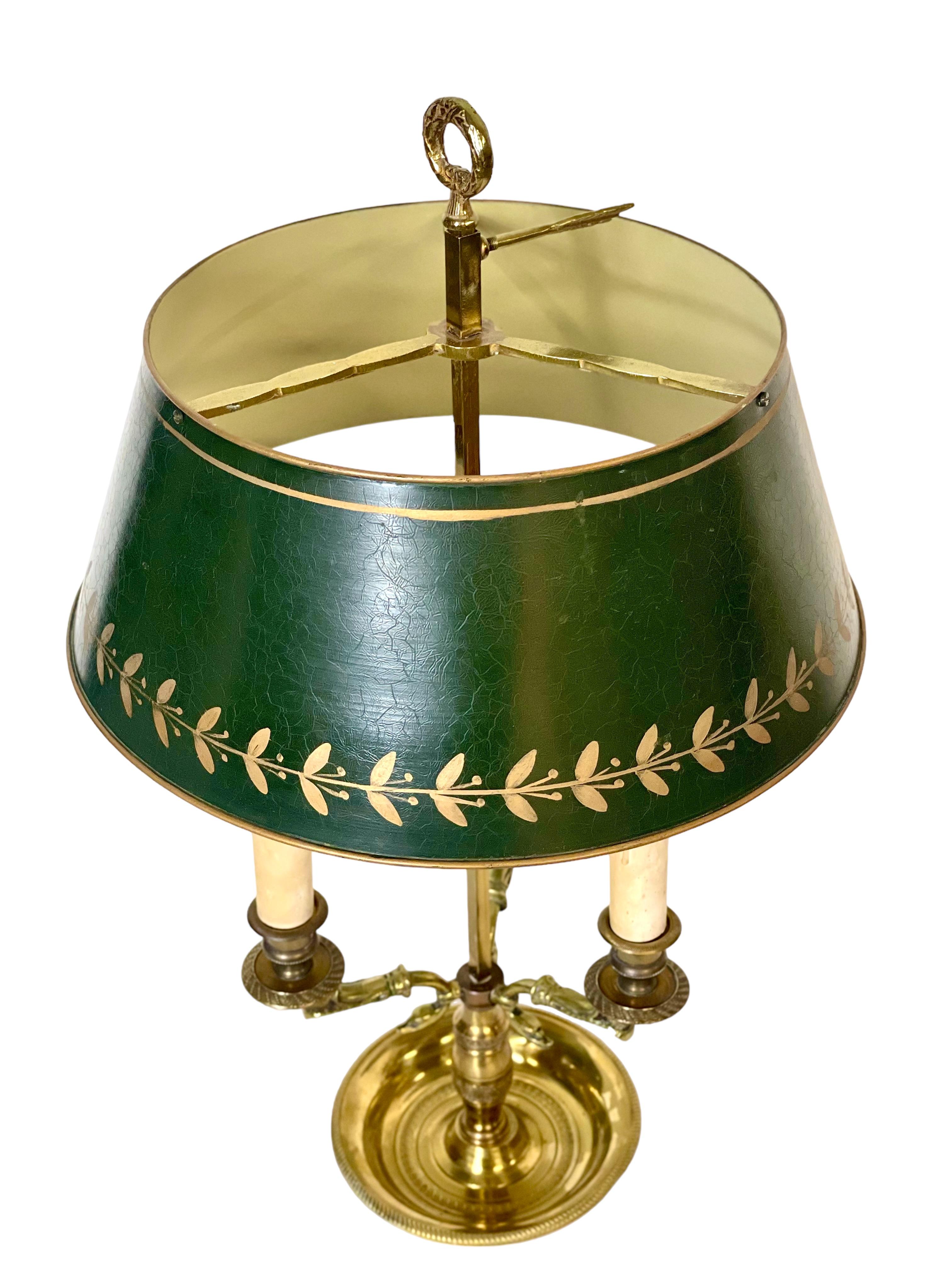 A late 19th century three-light 'Bouillotte' table lamp in gilded bronze and brass, with unusual duck's head styled arms and a typical green lacquered metal (tole) shade. Designed in the empire style, the lamp features a baluster stem, with an
