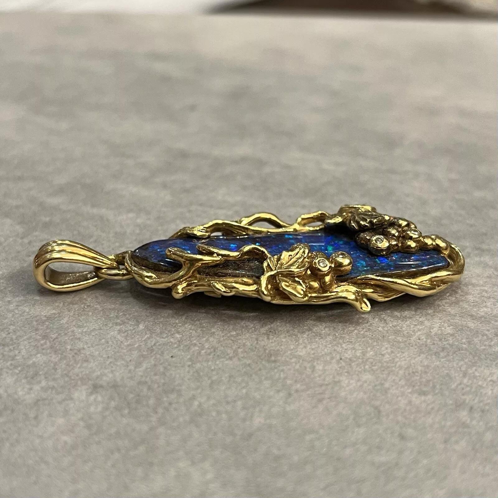 19.57 ct Boulder Opal and Diamond Pendant in 18k Yellow Gold 

Boulder Opal Pendant features a long Oval Boulder Opal with Blue and Green Play-of-Color, weighing 19.57 carats, accented with Round Brilliant Diamonds all set in a hand made 18k Yellow