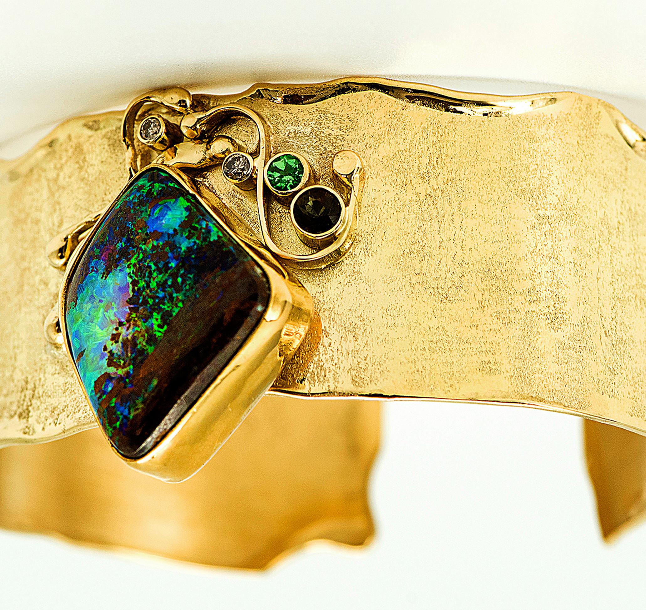 Boulder Opal cuff bracelet with a spectacular green matrix boulder opal.  The cuff is designed with 18k gold and is about 1.0