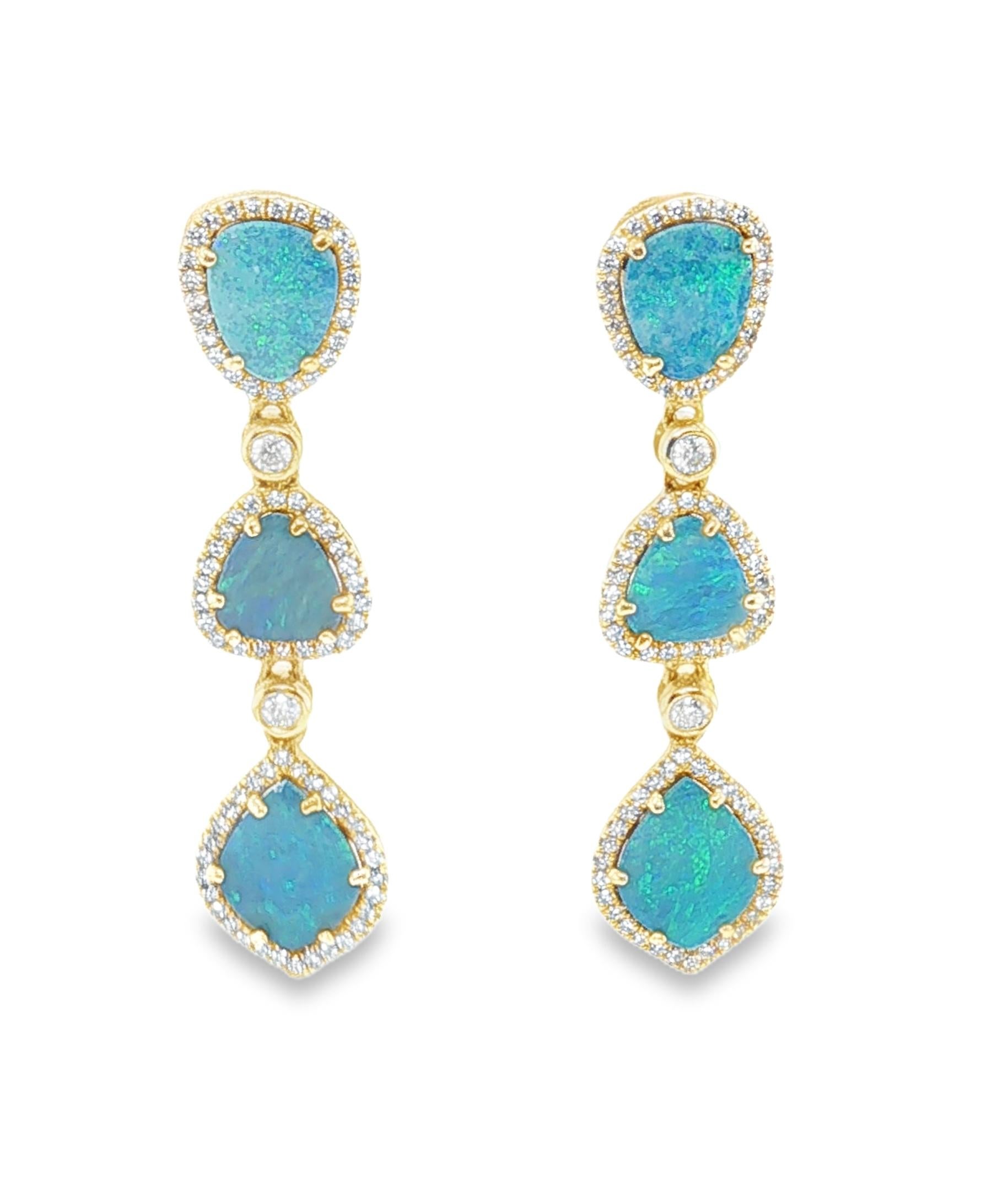 Estos elegantes pendientes colgantes presentan hermosos ópalos de canto rodado engastados en oro amarillo de 14k con diamantes de talla brillante simple y completa. Los ópalos son llamativas formas libres con impresionantes juegos de color azul y