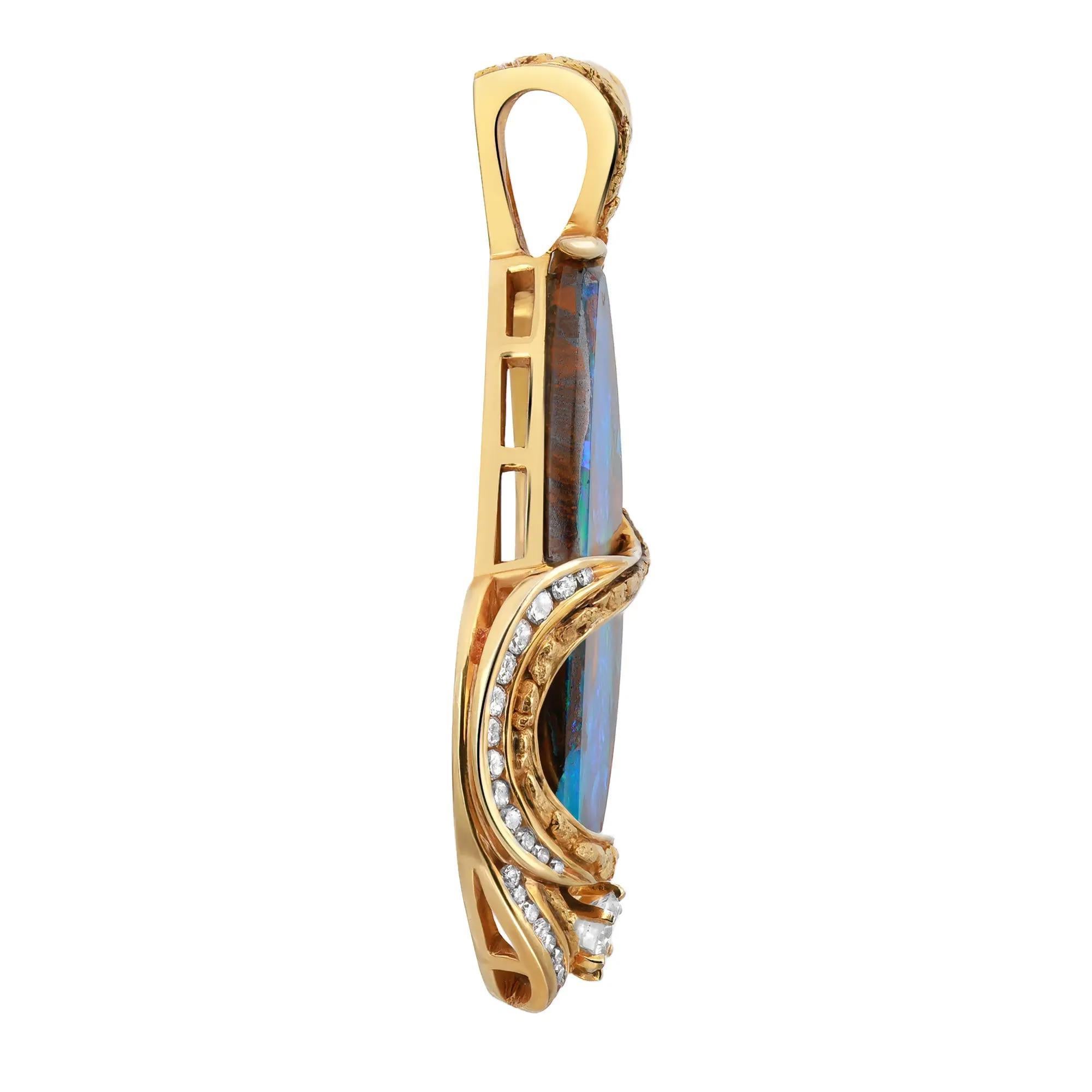 Vibrant et coloré, cet exquis pendentif en forme de poisson est réalisé en or jaune 14 carats. Il met en valeur une opale de roche multicolore en son centre, recouverte d'un motif en or jaune serti de diamants. Un diamant de taille ronde serti sur