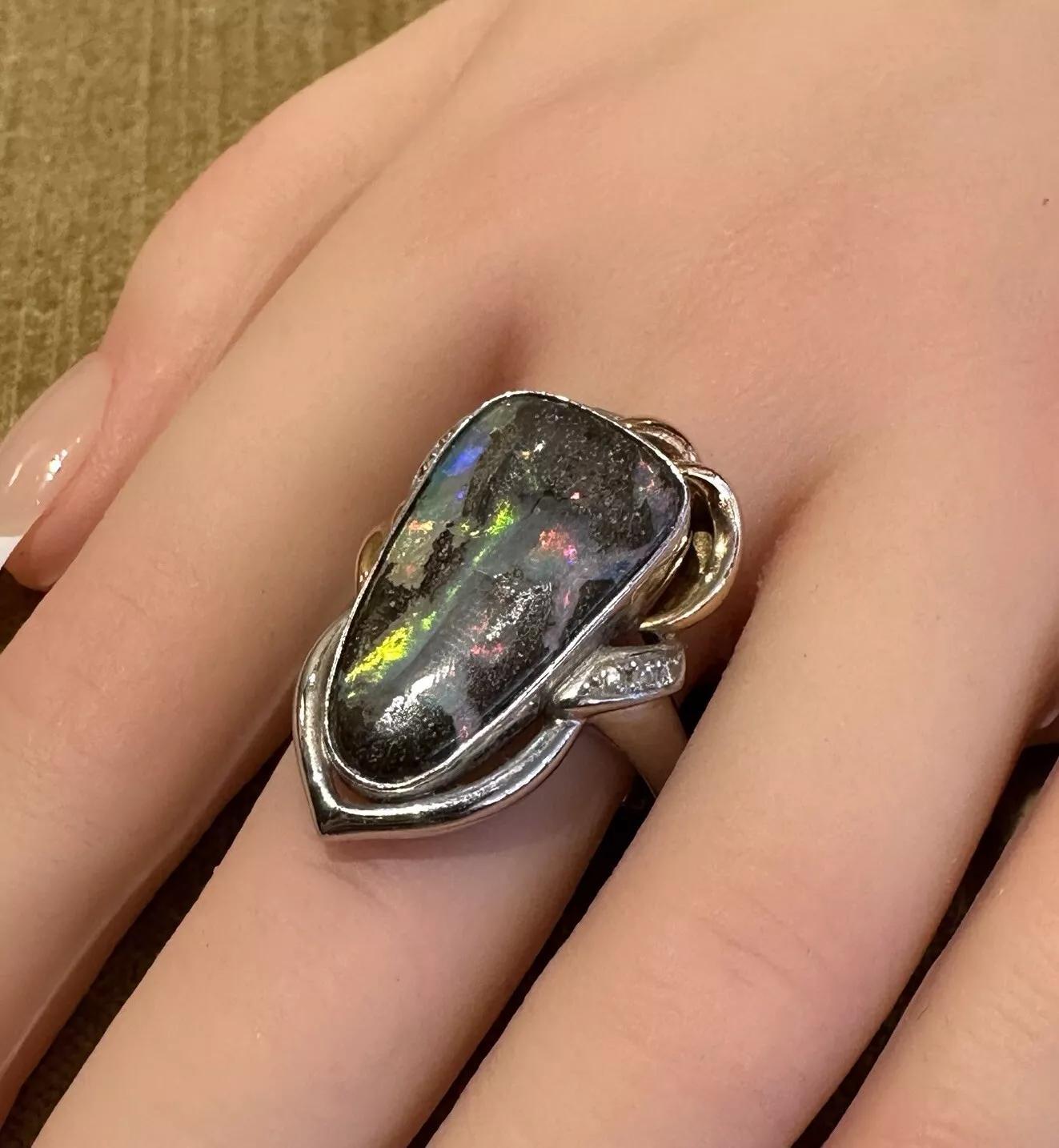 Boulder Opal and Diamond Ring in 18k Yellow Gold and Platinum 

Boulder Opal and Diamond Ring features Natural Boulder Opal weighing 12.32 carats in an elongated shape with Pink, Green, and Blue Play-of-Color on a Dark Brown background accented with