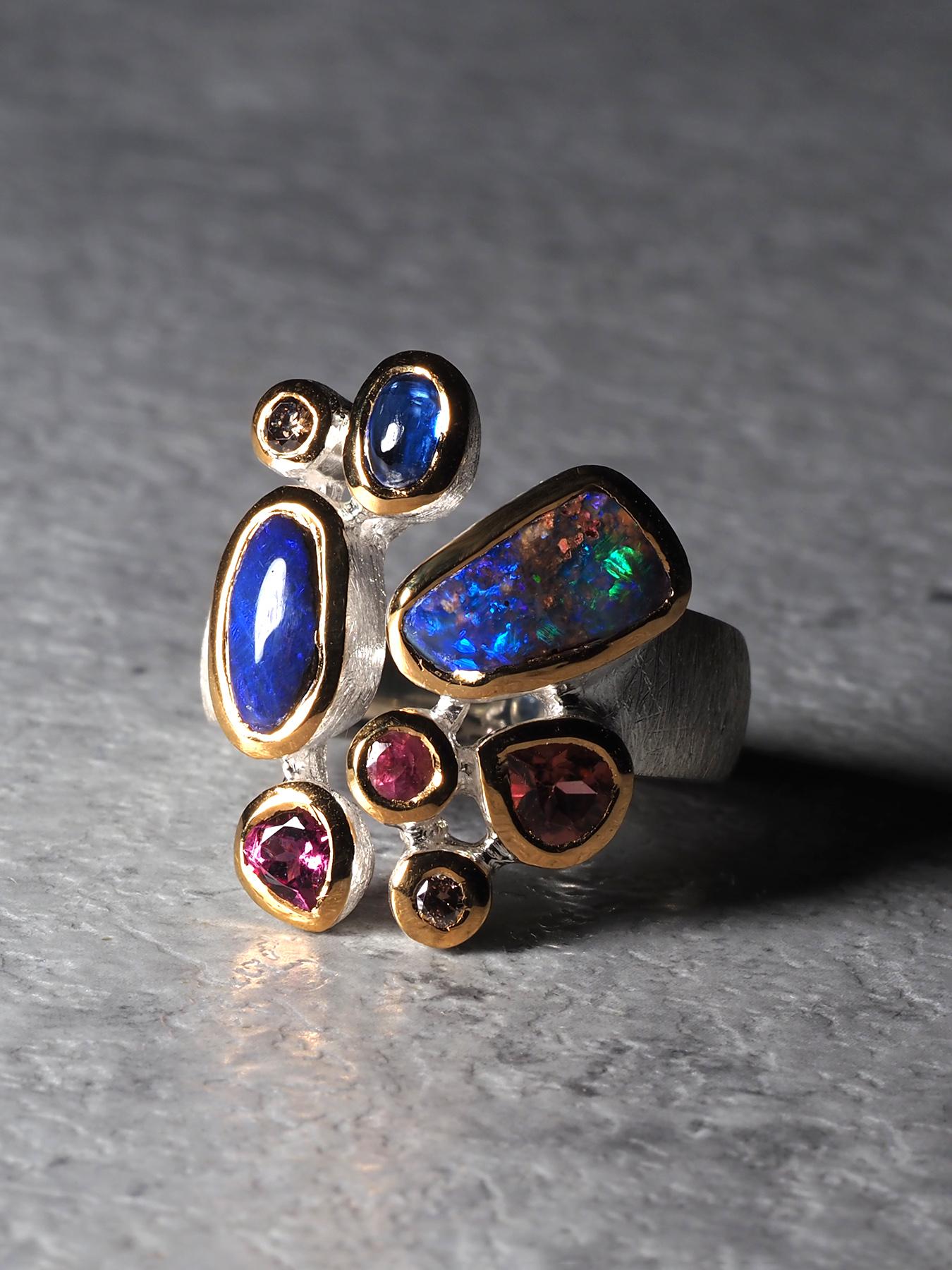 Opal & Edelstein Cluster Ring - Silber mit 18K Gold Fassungen

Ein leuchtender, einzigartiger Edelsteinring, handgefertigt aus 925er Silber mit reicher 18-karätiger Goldeinfassung. Dieses einzigartige Cluster-Design zeigt zwei natürliche Opale, die