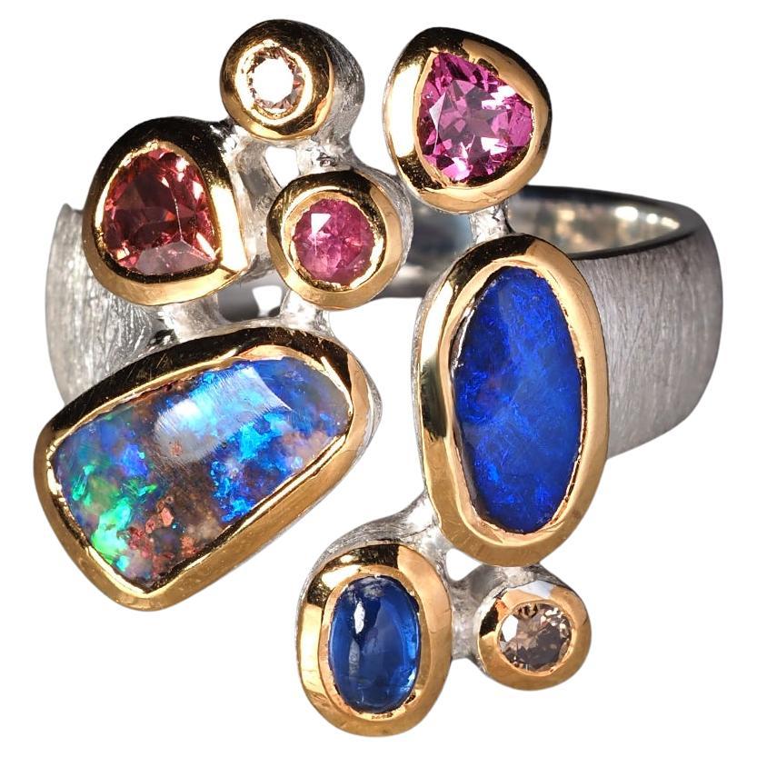 Ring aus Silber mit Boulder Opal und kostbarem Opal in vergoldeter Fassung und Saphir