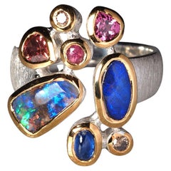 Ring aus Silber mit Boulder Opal und kostbarem Opal in vergoldeter Fassung und Saphir