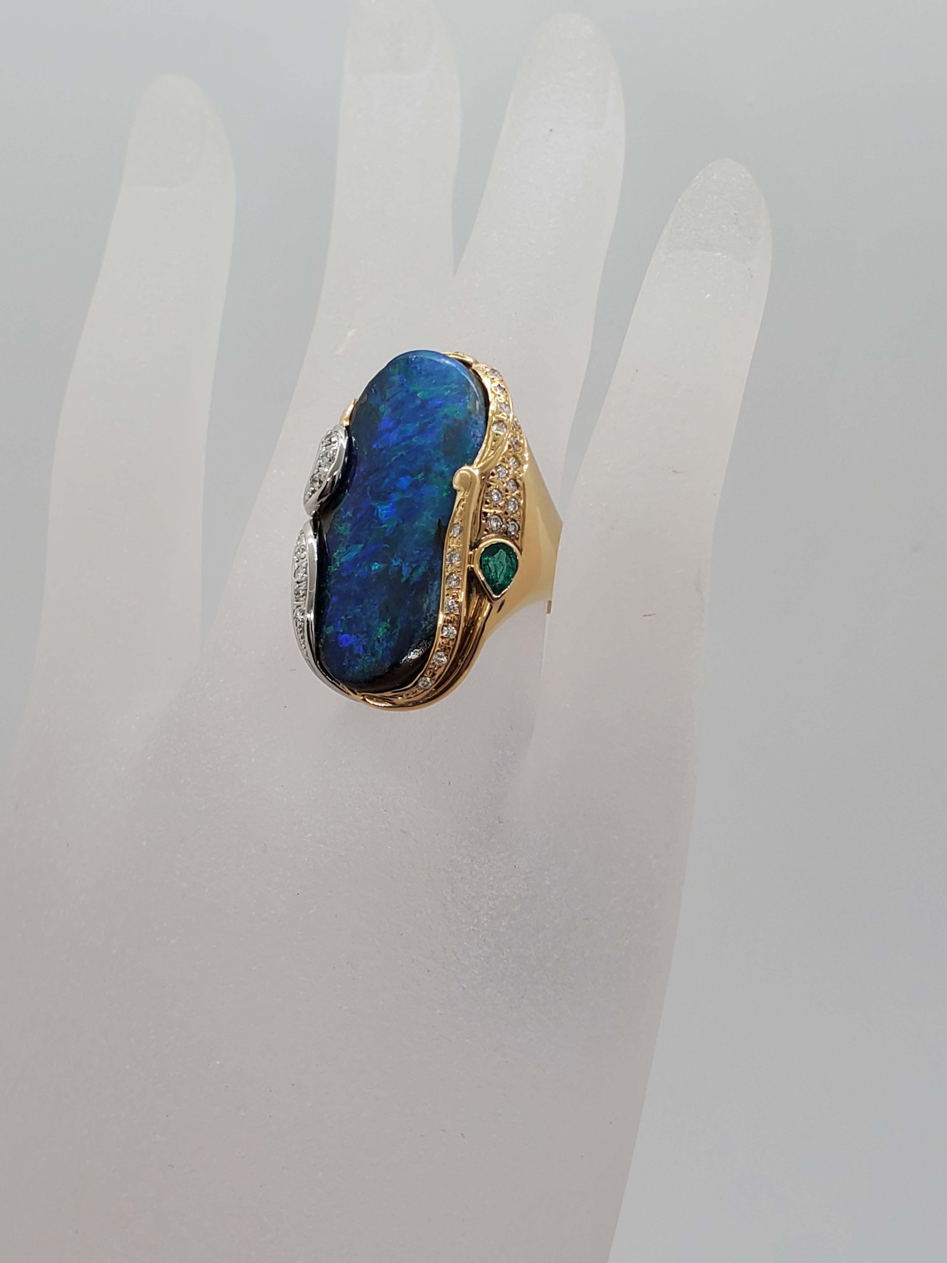 Spectacular estate boulder opal ring featuring a 22.10 ct gorgeous green blue opal and 0.59 cts of emerald pear shape and white diamond rounds.  Handcrafted in 18k white and yellow gold. Excellent condition.  