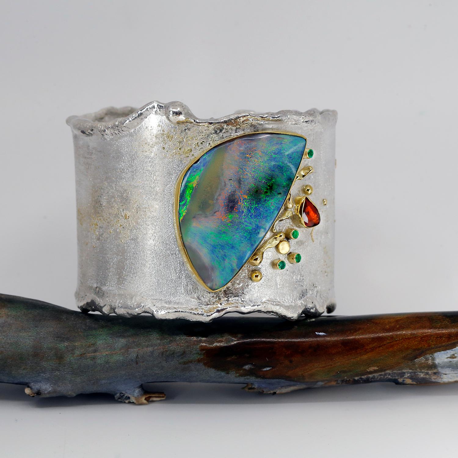 This is a stunning boulder opal with all the fire, color and jump one wants in an boulder opal. I used a rose cut sapphire to pull out the orange and pink fire, and emeralds to tease out the green. It is 2