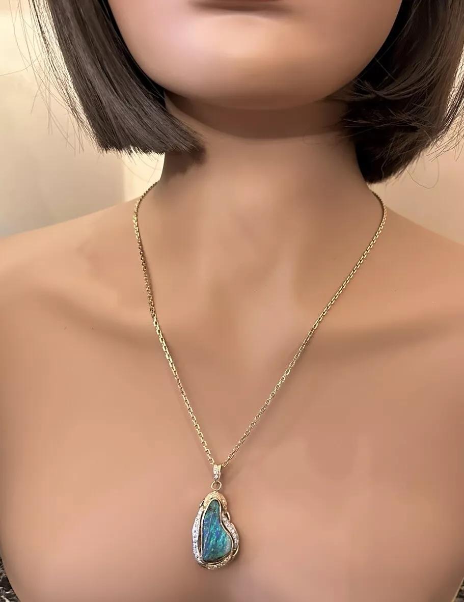Boulder Opal & Diamond Pendant Necklace in 18k Yellow Gold and Platinum

Opal Pendant Necklace features a Large Boulder Opal set in 18k Yellow Gold with Round Brilliant Diamonds set in 18k Yellow Gold and Platinum. 

Total boulder opal weight is