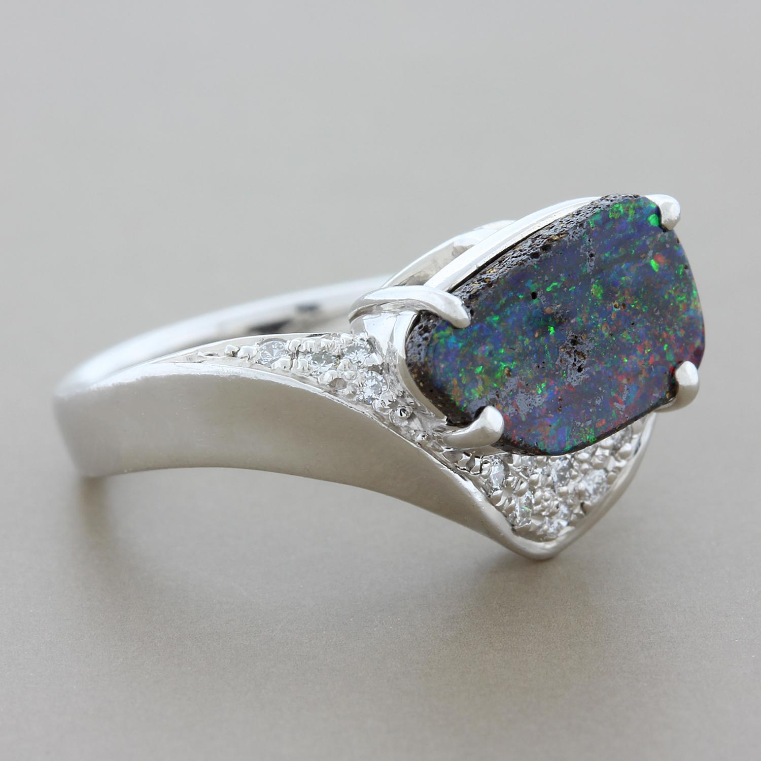 A top gem quality 2.23 carat boulder opal with exceptional play of color showing strong flashes of reds and other colors. It is accented by 0.14 carats of round cut diamonds pave set in platinum. A ring for someone who appreciates fine quality