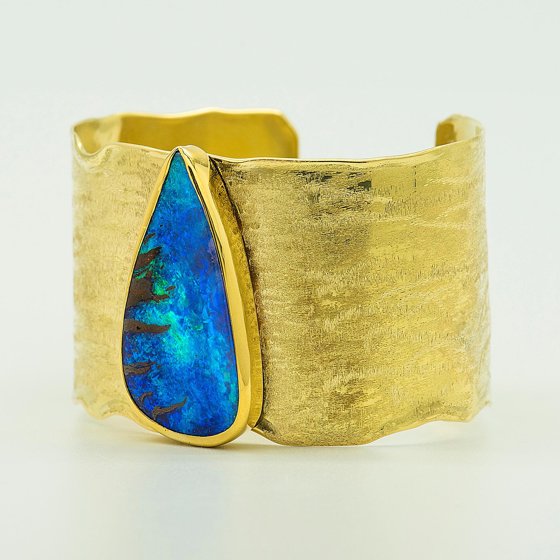 Boulder opal cuff bracelet in 22k gold and 18k gold.  Boulder opal is from Queensland, Australia primarily from the Winton area.  This blue green boulder opal is a classic color,  the chocolate matrix displaying a pattern on the left like a big cat