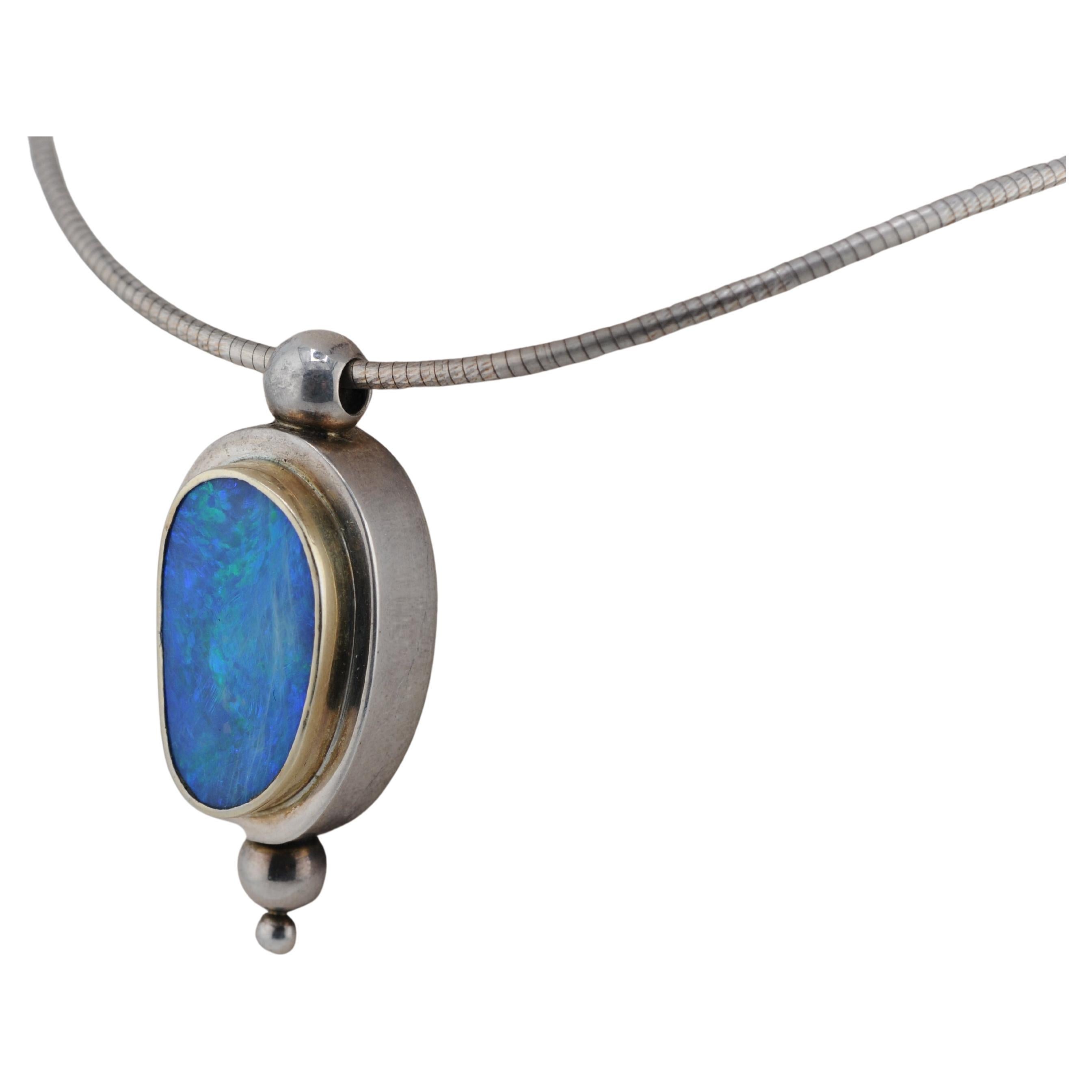 Eine auffällige Halskette aus 925er Sterlingsilber mit goldenen Akzenten. Das Herzstück ist ein kühner und natürlicher australischer Boulder-Opal, der ein lebhaftes Farbenspiel und eine einzigartige natürliche Musterung aufweist. Ein wunderbar