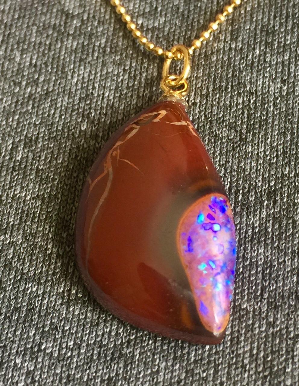 An Australian Boulder Opal in Red Ironstone Matrix hanging from a 20