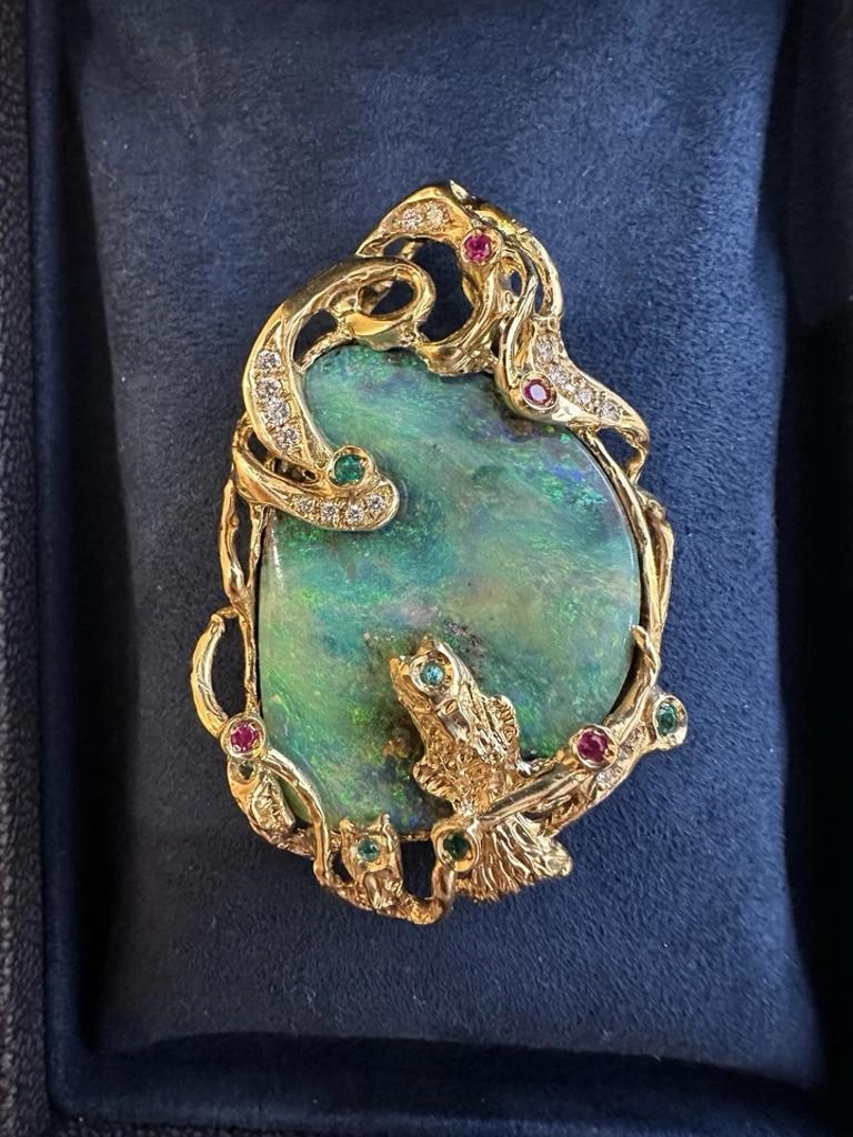 Pendentif Boulder Opal avec pierres précieuses et diamants en or jaune 18k

Le grand pendentif en opale de Boulder présente une opale de Boulder de 43,21 carats avec des jeux de couleurs bleu, aqua et jaune dans une monture en or jaune 18 carats