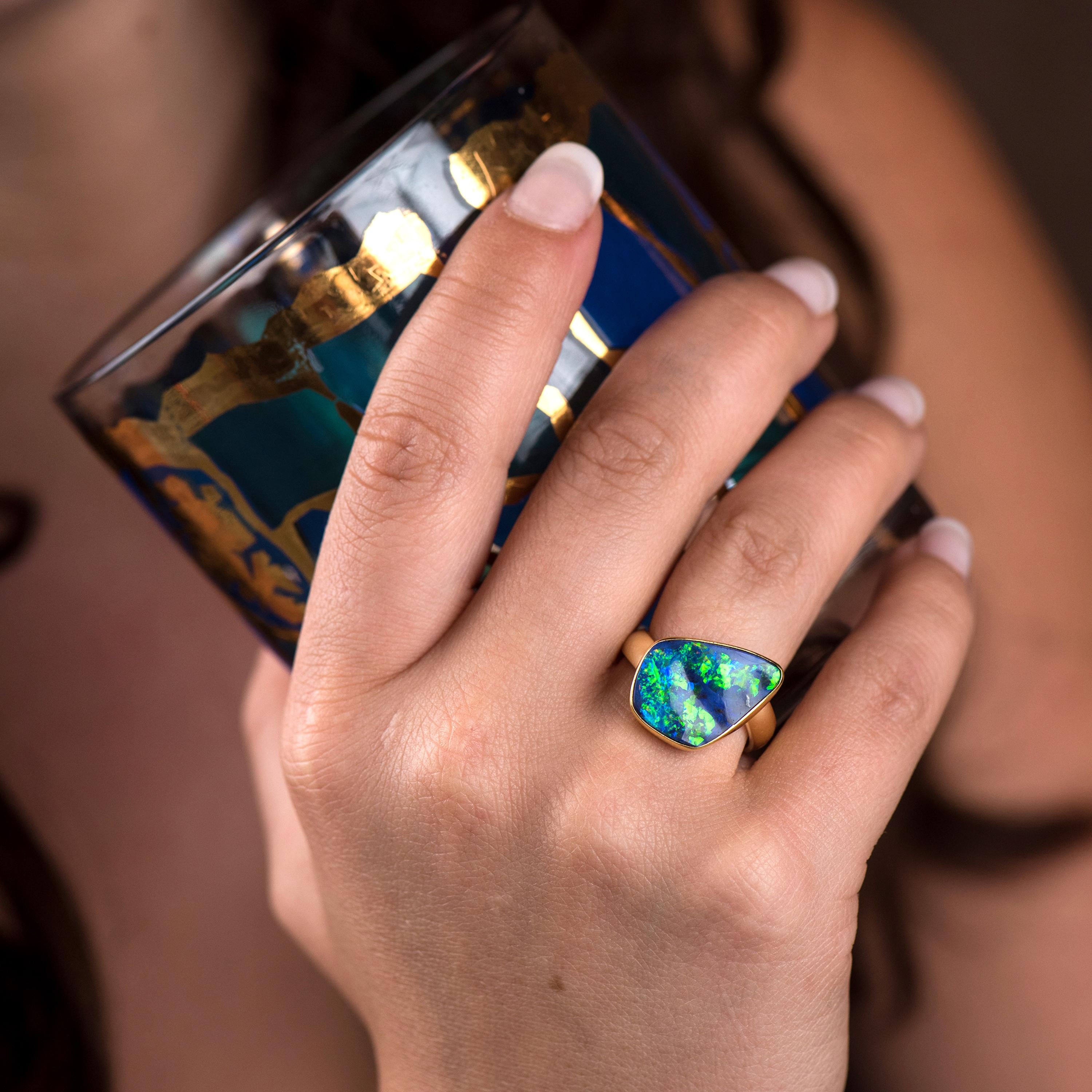 Boulder opal ring in 22k gold with a 18k gold shank.  The large flashes of blue, green with a tad of purple is spectacular!  The 4mm gold band is off set giving it a unique look.  A boulder opal ring you will love forever.  Size 7.5 
