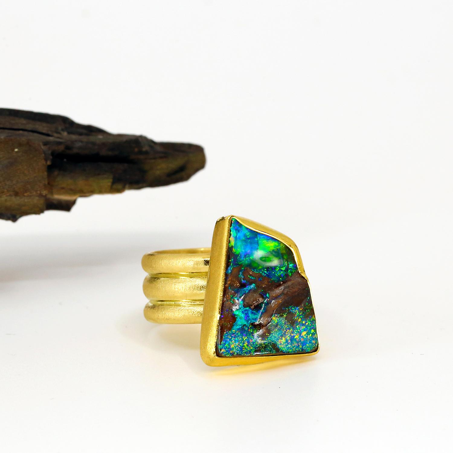 This Boulder opal ring has blue green fire with an undulating roof surface making it organic looking, and preserving the raw nature of the opal gem. Anyone, will love this ring. The triple half-round wire on the band makes for a wide, yet very
