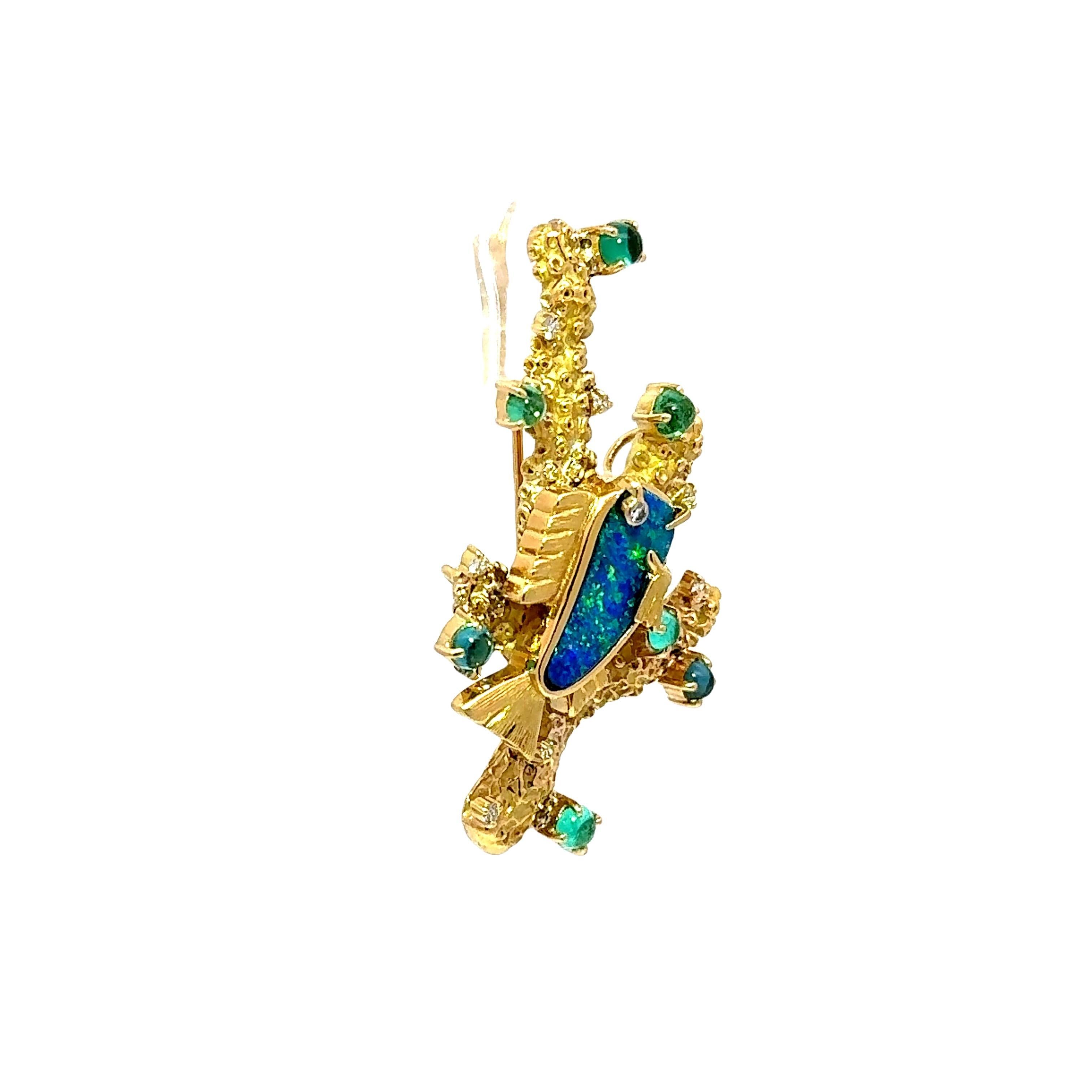 A modern and elegant brooch featuring a lovely Australian boulder opal as its centerpiece, radiating vivid blue and green colors. Surrounding the opal are cabochon-cut Paraiba tourmalines, ranging in color from classic blue to stunning greens,