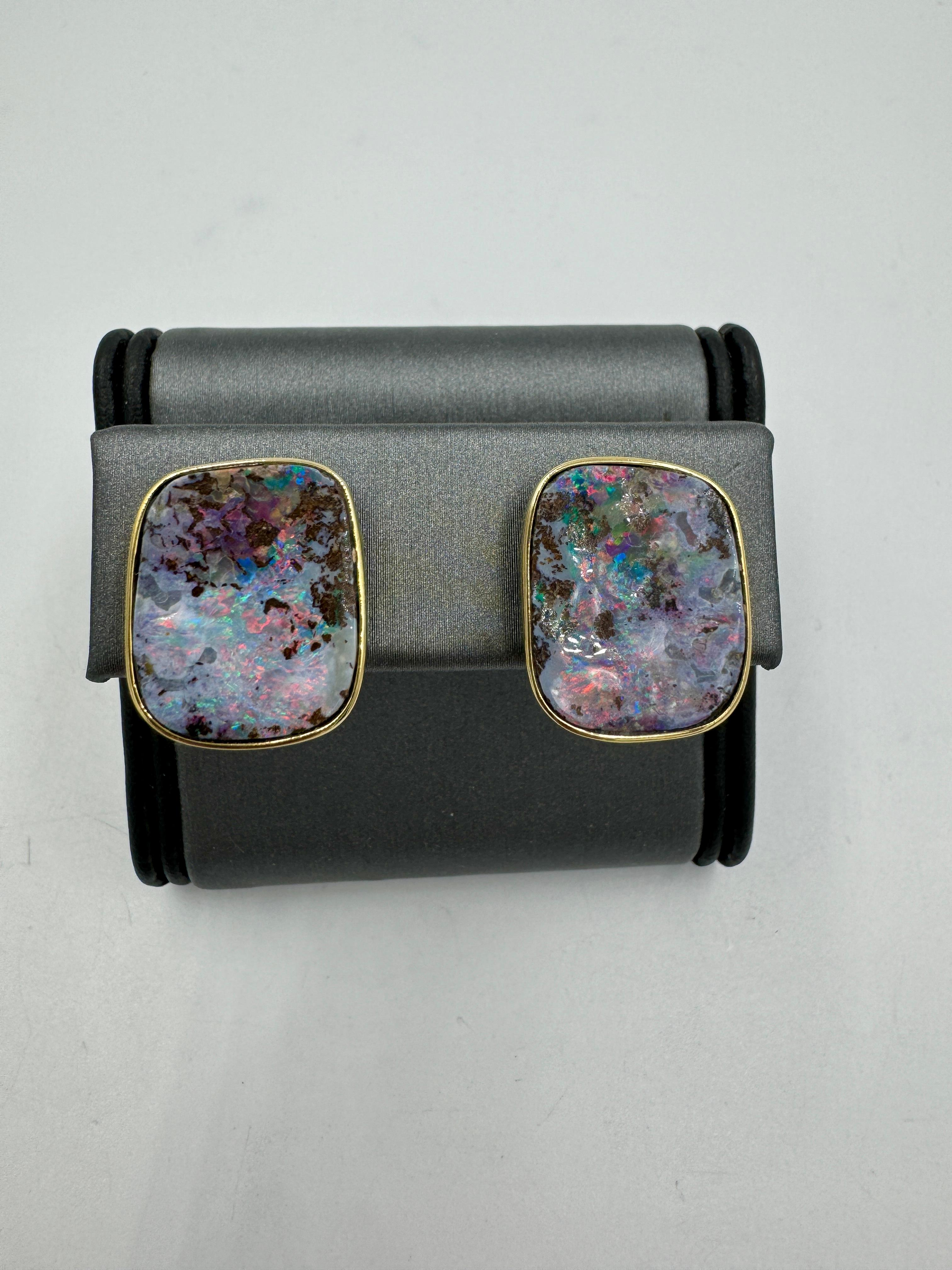 Estate Boulder Opal yellow gold omega and post earrings, circa 1990s.

  These Australian boulder opals were custom set in 18k yellow gold bezel settings.  The opals have red blue and green fire that comes out when moving around in the light. The