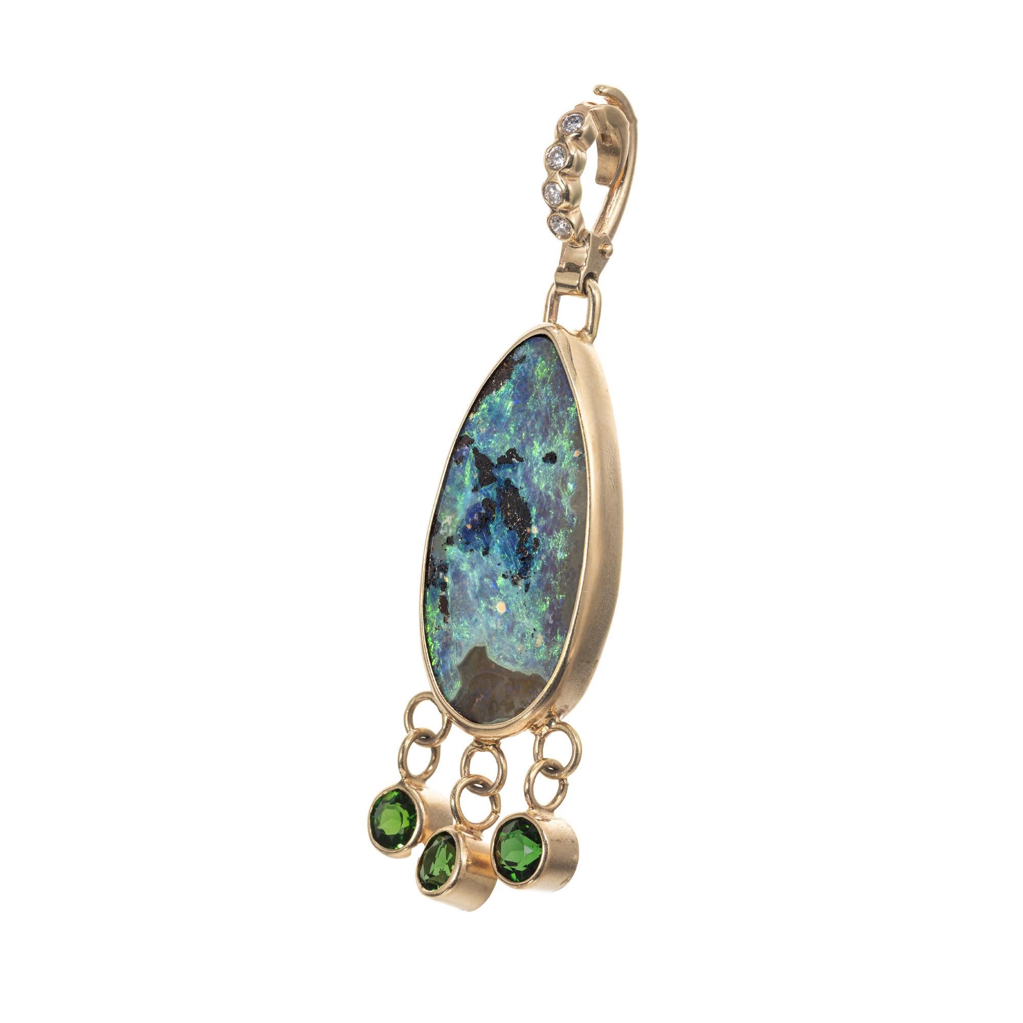 Opal, diamond and tourmaline pendant enhancer. Pear shaped multi color Boulder Opal mounted in a 14k yellow gold bezel frame, accented with three round bezel set deep green tourmalines and four round cut diamonds along the bail. The colors in the