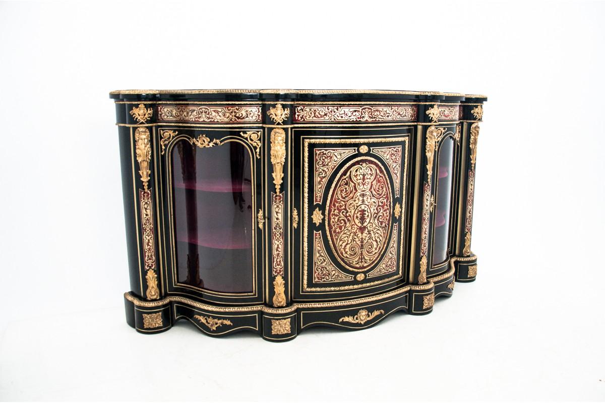 Unique inlaid Boulle work panels of inlaid brass and tortoiseshell, applied with four classical caryatid ormolu mounts in between glazed arch panel doors enclosing a red velvet lined shelved interior. In the reverse of the central door with brass