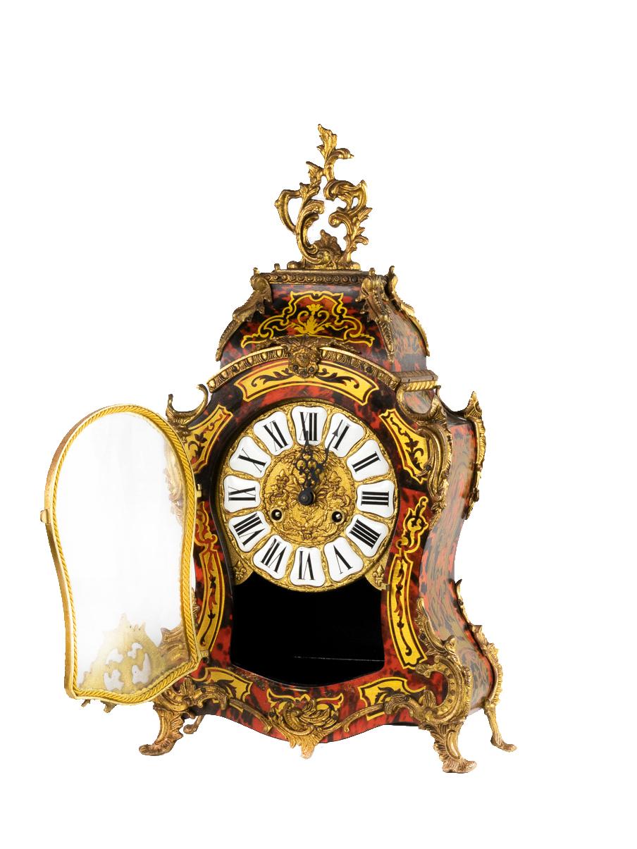 A Boulle Pendulum clock with tortoiseshell color, detailed sun on the pendulum, feet and head in gilded bronze letterhead; mechanism working and frecently reviewd. Original key
