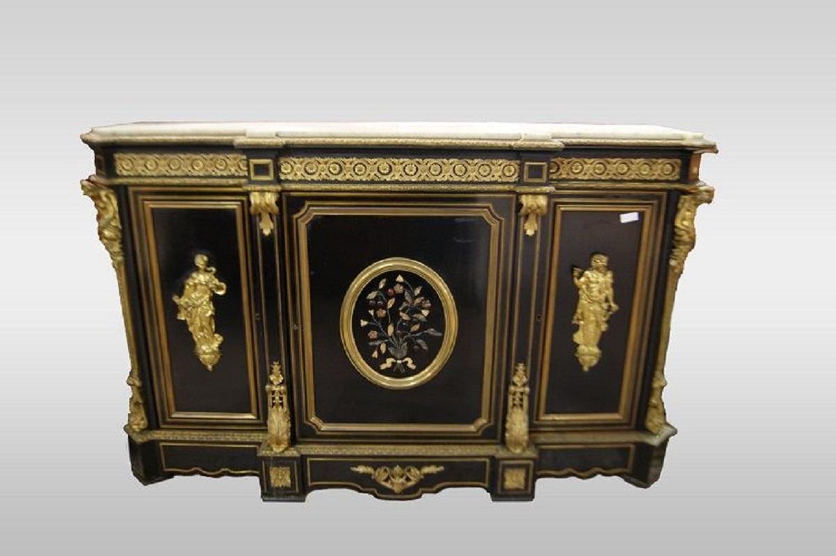 French three-door sideboard from the first half of the 1800s, in Boulle style, made of ebonized wood. It features a white marble top and rich bronze appliques with hard stone inlays.

Origin: France

Period: First half of the 1800s

Style: