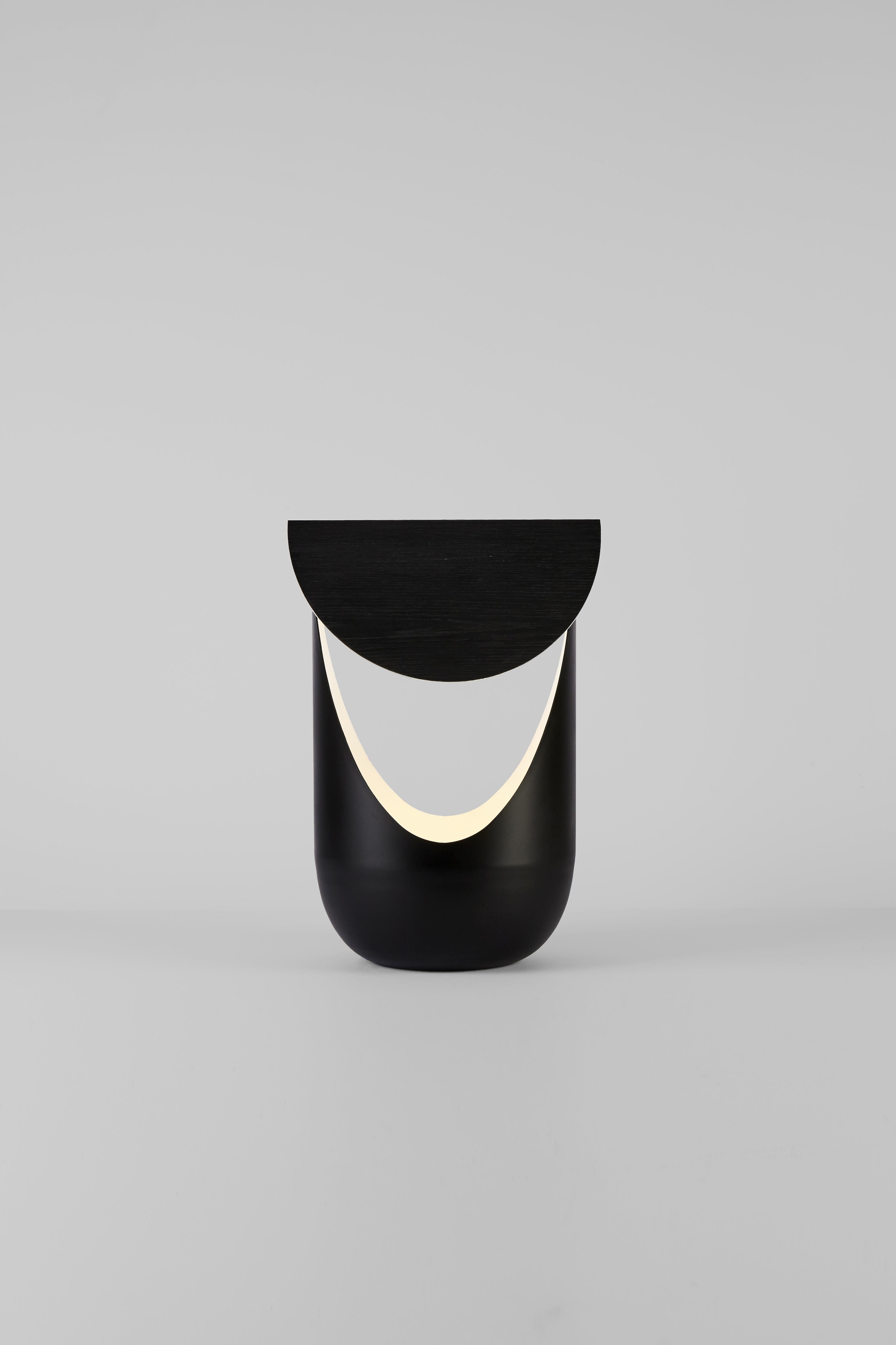 Spinoff compact de la série originale, la lampe de table bounce de Karl Zahn combine un abat-jour en aluminium plié et une source lumineuse à positionnement indépendant. Un côté de l'abat-jour est blanc pour refléter l'éclairage, tandis que l'autre