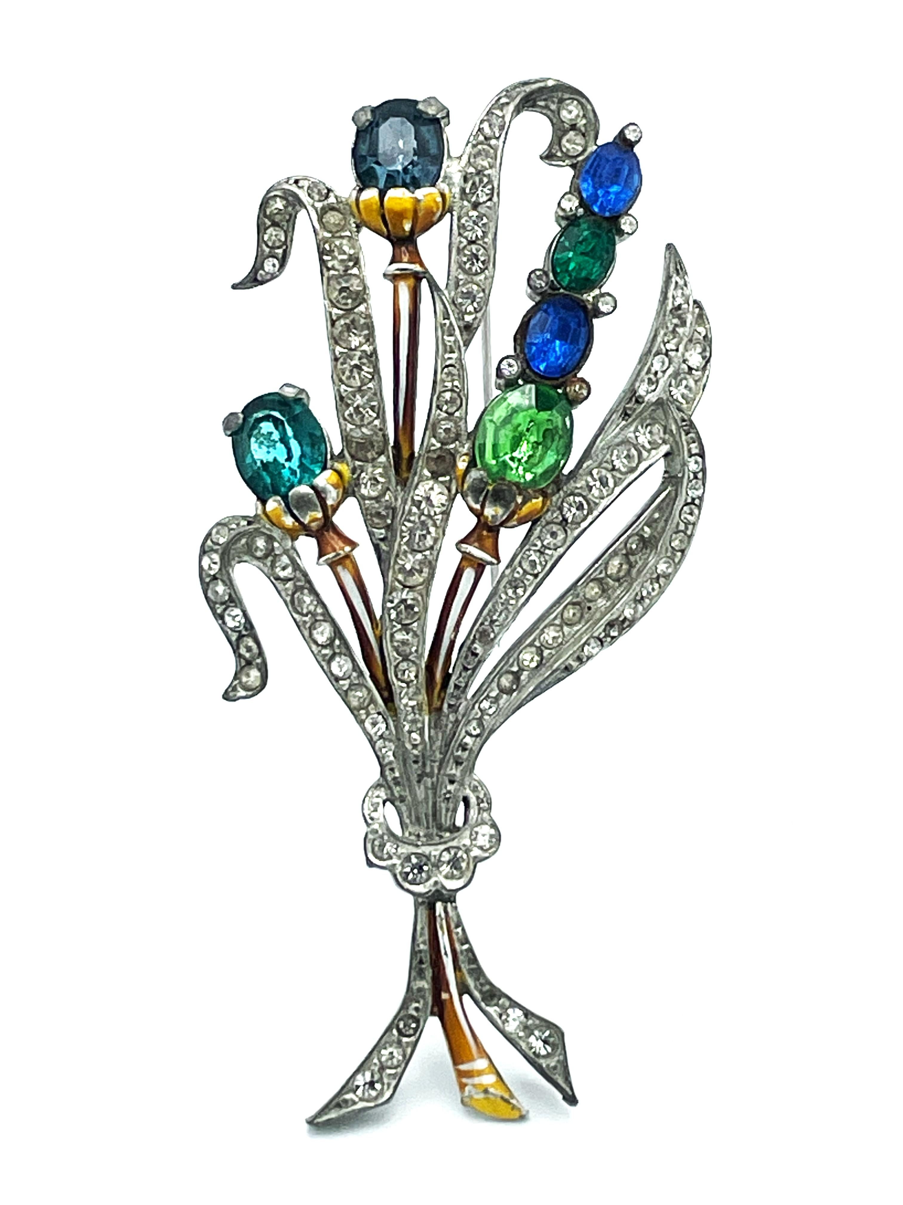 Very early bouquet brooch from the 1930/40s USA. Blue - green cut rhinestones and the leaves filled with clear set rhinestones. The brooch is made of potash, typical for this time.

Dimensions:
Height of the brooch 9 cm, width 4.5 cm
This early