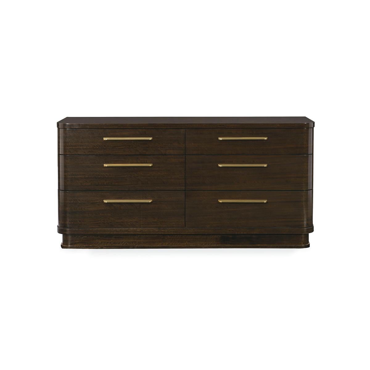 Classic era details come to life in this contemporized six-drawer dresser. Distinguished by its generously rounded corners, and recessed plinth base, this piece takes on a refreshed style in fumed figured eucalyptus that has been finished in Aged