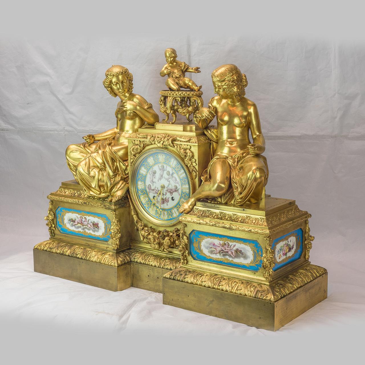 A Monumental Bourdin French figural gilt bronze mantel clock, depicting two women seated on the plinth with garland decoration and a cherub atop. Movement with rear plate stamped Bourdin A Paris and 3235. 

Maker: Bourdin à Paris
Origin: