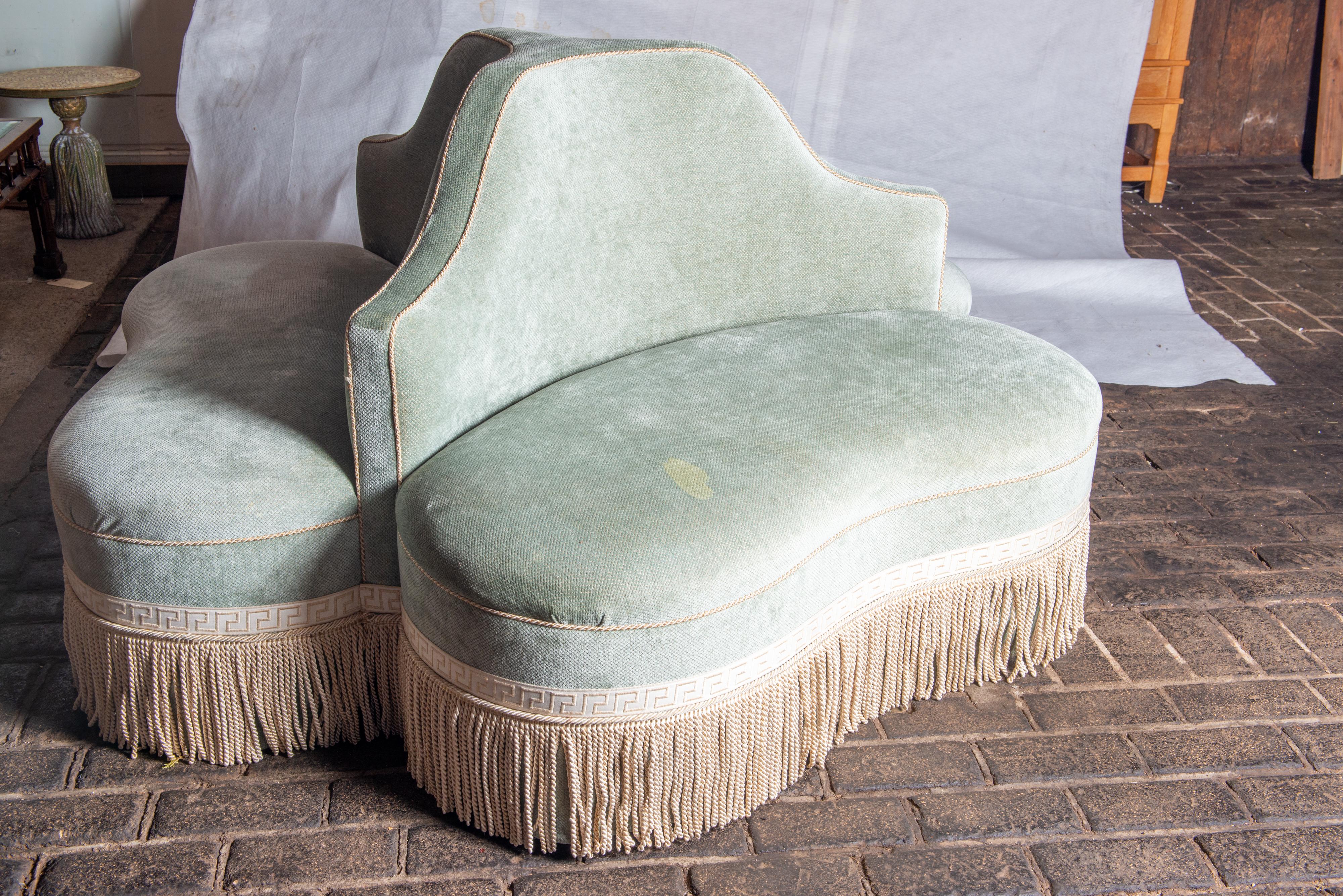 Stylish blue-grey velvet bourne, round sofa, or circular banquette with greek key trim long fringe detail. The sofa is divided into three sections with three curved backs and three tight seat cushions. Beautifully upholstered. Seat cushions have