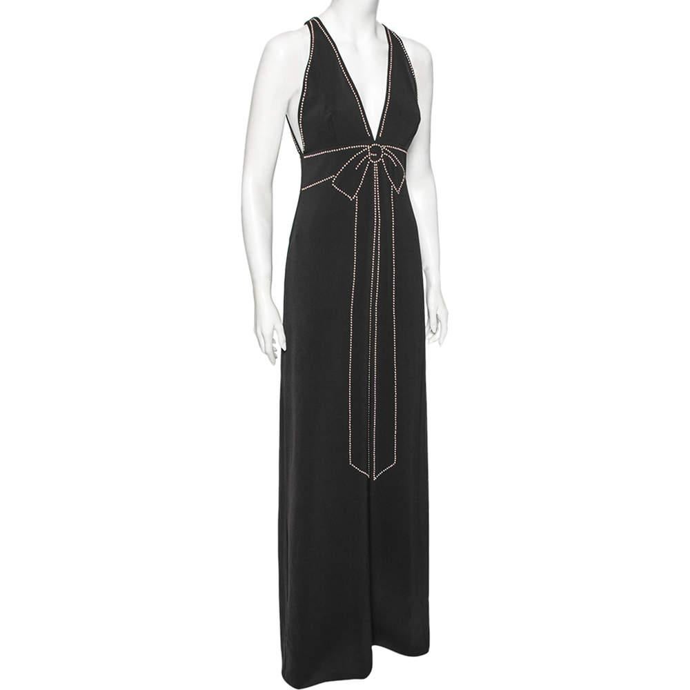 This Boutique Moschino gown is all about grace and style. Tailored perfectly, it has a plunging neckline, sleeveless design, and zip closure. Contrasting embellishments help outline its silhouette and create a bow-like effect on the front. Style the