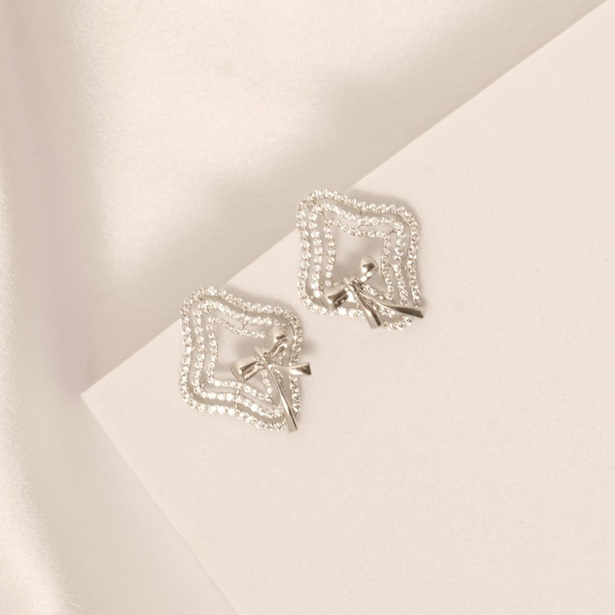 Todas nuestras piezas de joyería están certificadas por un laboratorio externo como IGI, HRD, IDGL, GIN o SGL.

Estos llamativos pendientes presentan un diseño inspirado en un lazo con monturas onduladas forradas de diamantes en oro macizo de 14