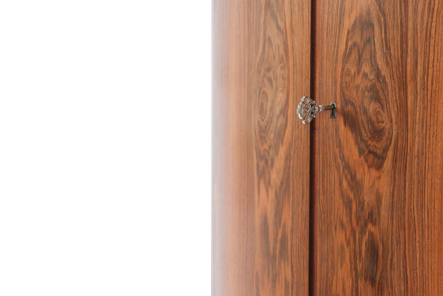 Dieser wunderschöne, unauffällige Eckschrank mit Bogenfront aus brasilianischem Palisanderholz wird mit Leichtigkeit zum neuen Mittelpunkt eines jeden Raumes. Die geschwungenen Türen geben den Blick auf einen mit Filz ausgekleideten Innenraum mit