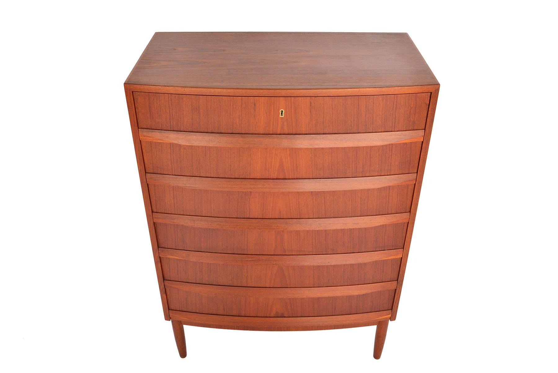 This Danish modern midcentury dresser in teak offers a stately profile. Beautifully cornered and banded, the case holds six bow front drawers with full profile pulls. In excellent original condition with typical wear for its vintage.

 