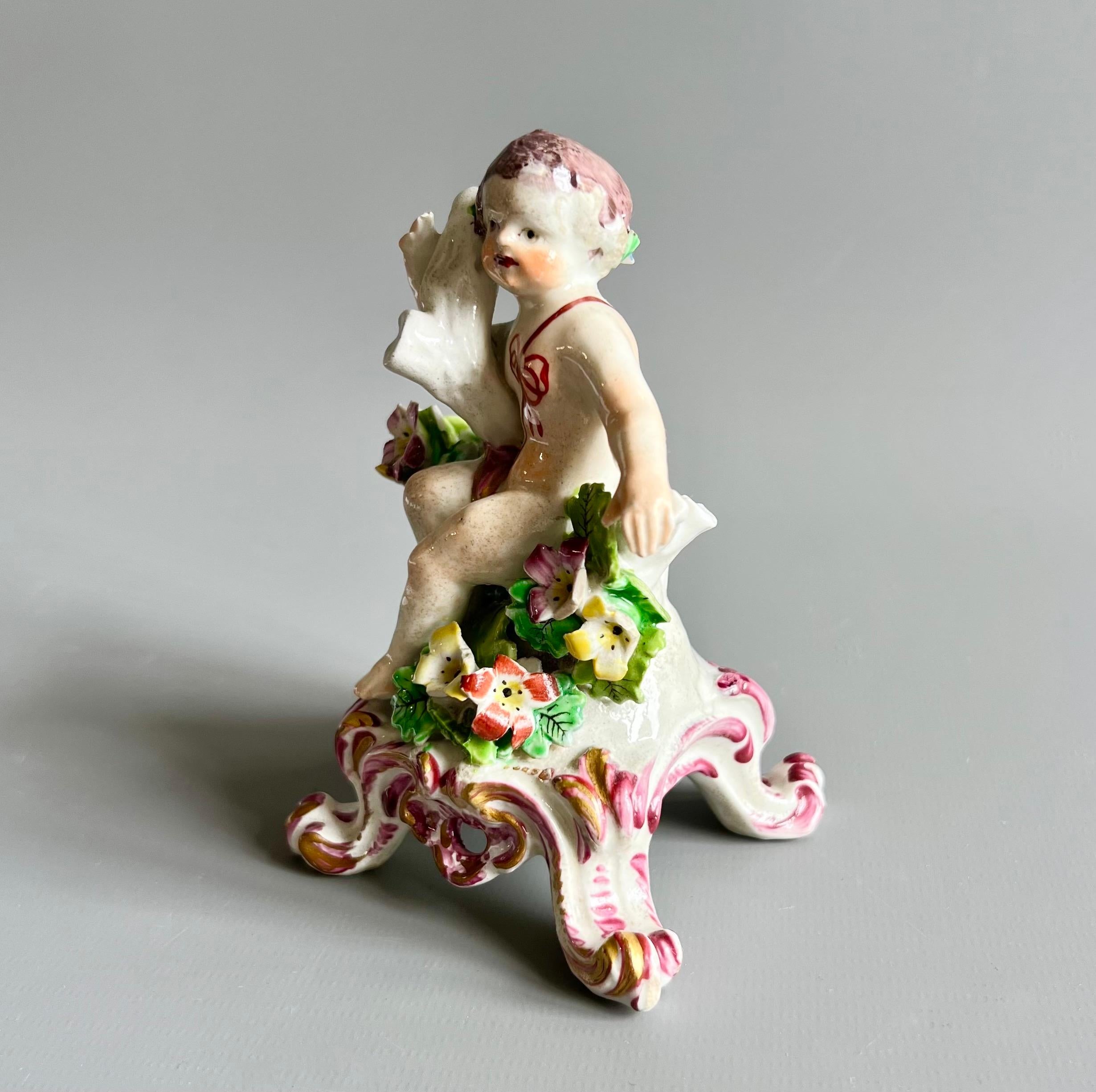 Dies ist eine wunderbare kleine Figur eines Jungen oder Putto, die um 1760 von der Bow Porzellanfabrik hergestellt wurde.

Die Bow Porcelain Factory war eine der ersten Töpfereien in Großbritannien, die Weichporzellan herstellte, und wahrscheinlich