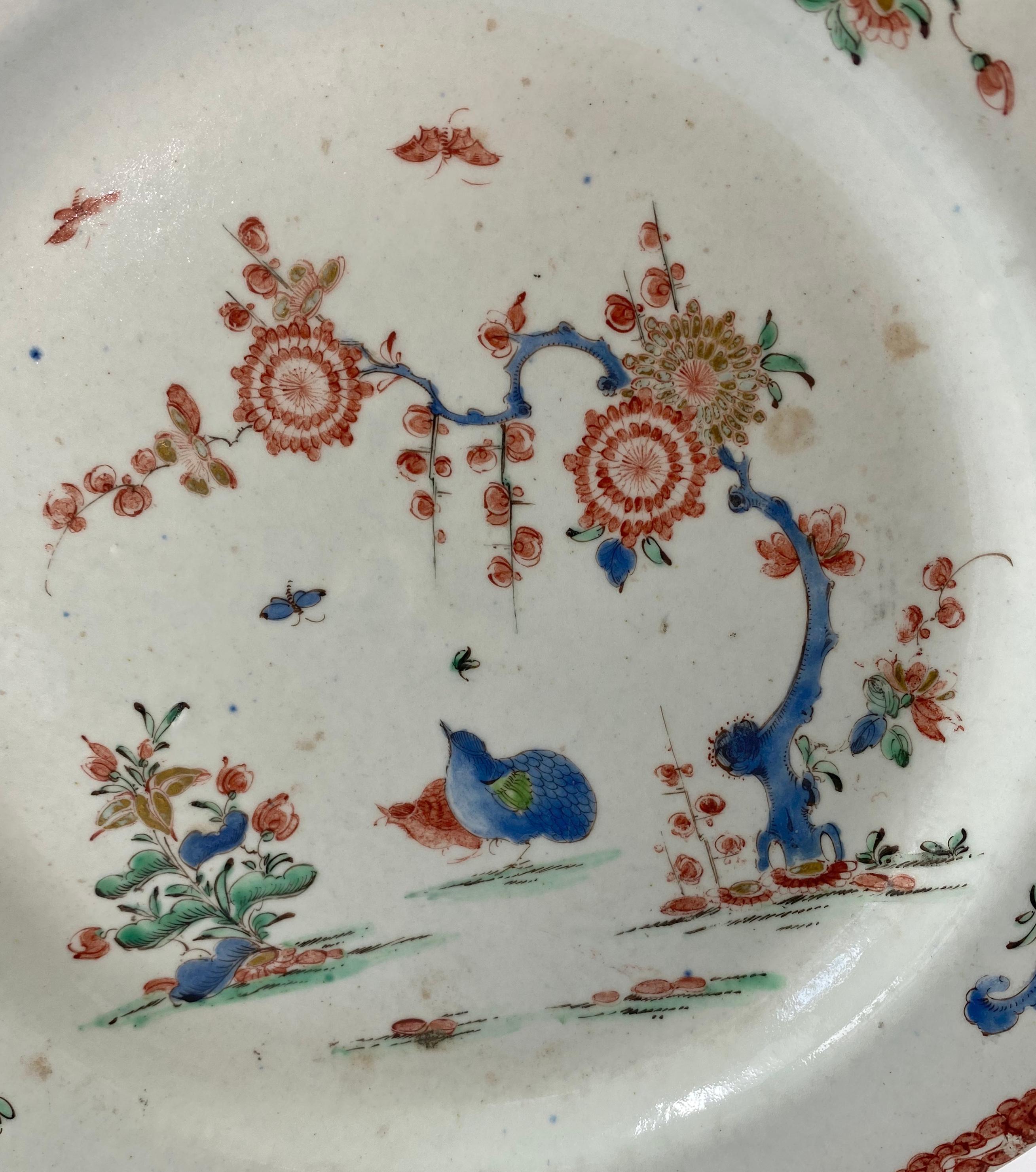 Bow porcelain plate, c. 1755. The octagonal plate, well painted, to the centre, with a representation of the Kakiemon Two Quail pattern, in vivid enamels. Having sprigs and sprays of flowers to the rim, within a border of iron red floral scroll, and