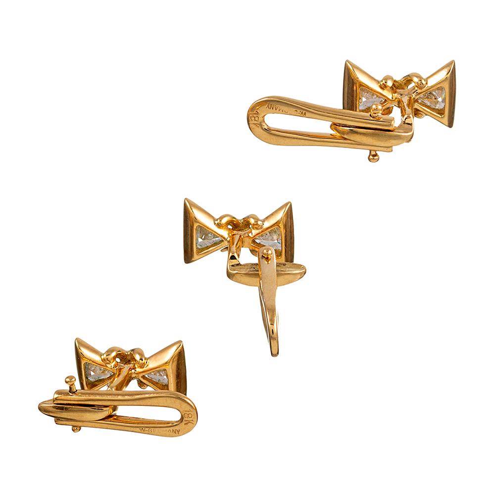 Made in West Germany of 18 karat yellow gold, the suite consists of a pair of cufflinks and three studs, each designed to resemble a bow tie with the points decorated with a trillion diamond. In total, the ten diamonds weigh approximately 3.75
