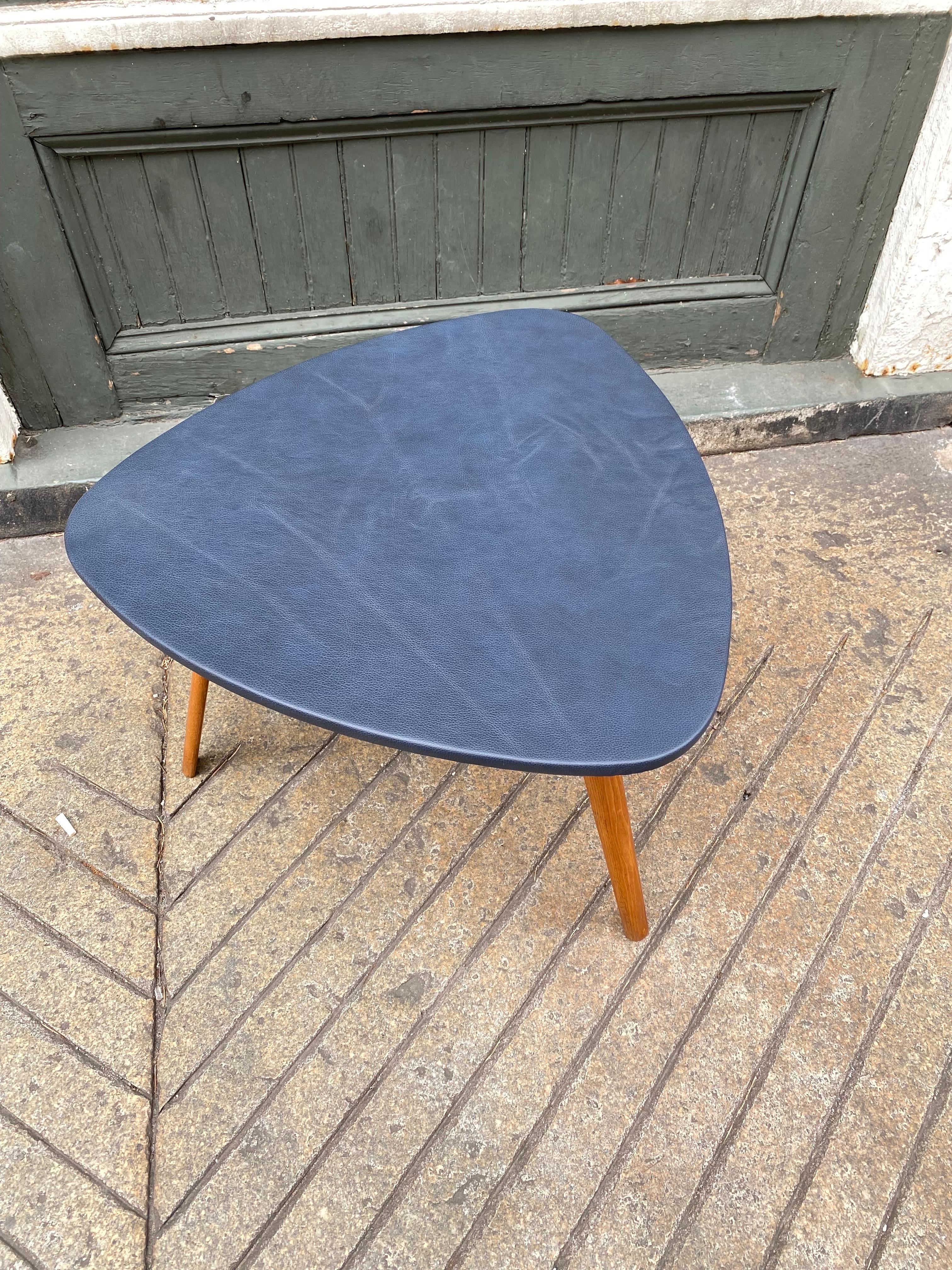 Bow-Wood 3 legged leather covered coffee table or end table. Simple graceful proportions with new dark blue leather. Wood is original and in nice condition, table retains it's original label to underside.