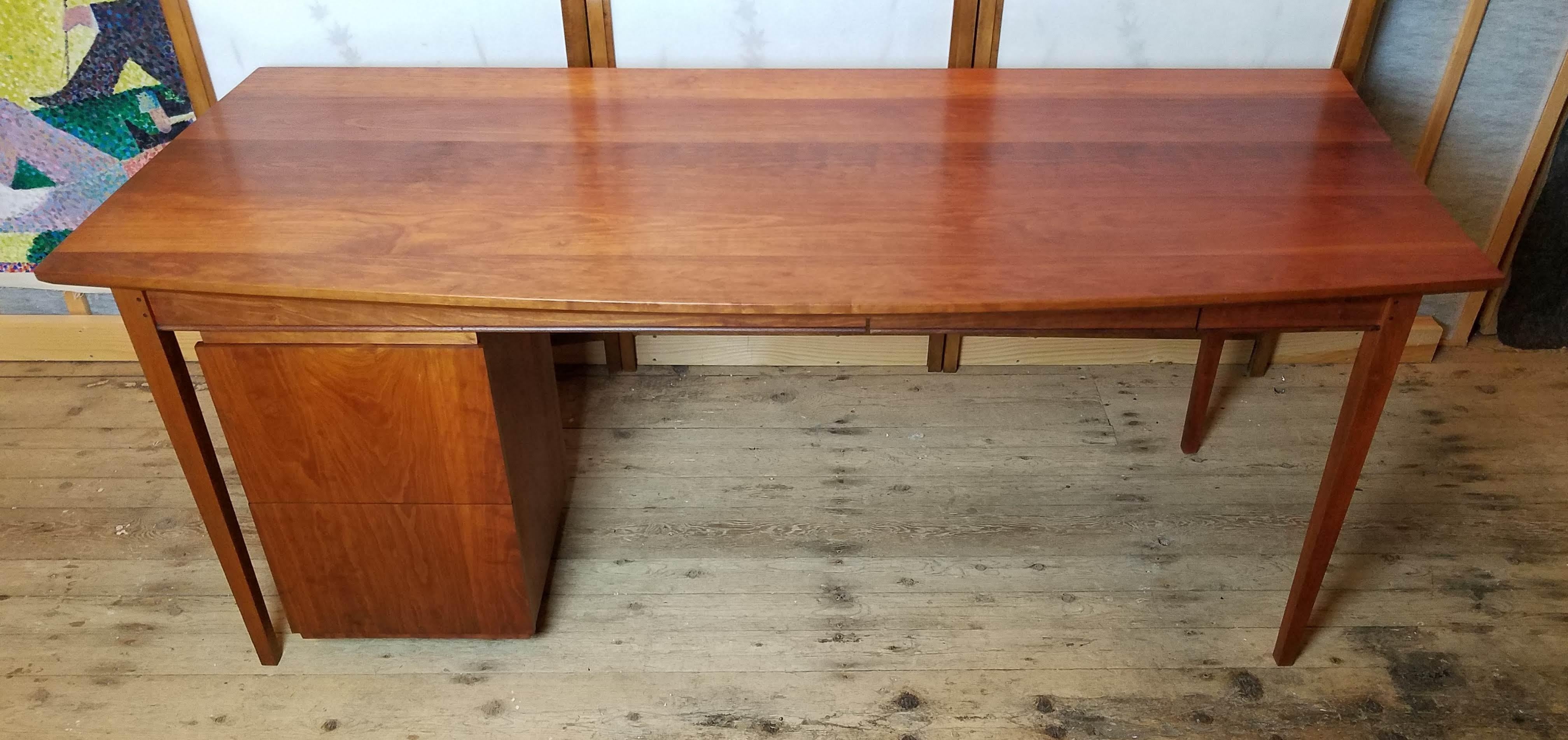 Bow front cherry desk with two suspended drawers studio built in Portland Maine in the 1980s in the style of Thomas Moser.
A hand pegged construction with different radius arcs for the ends of this beautifully grained solid cherry planked