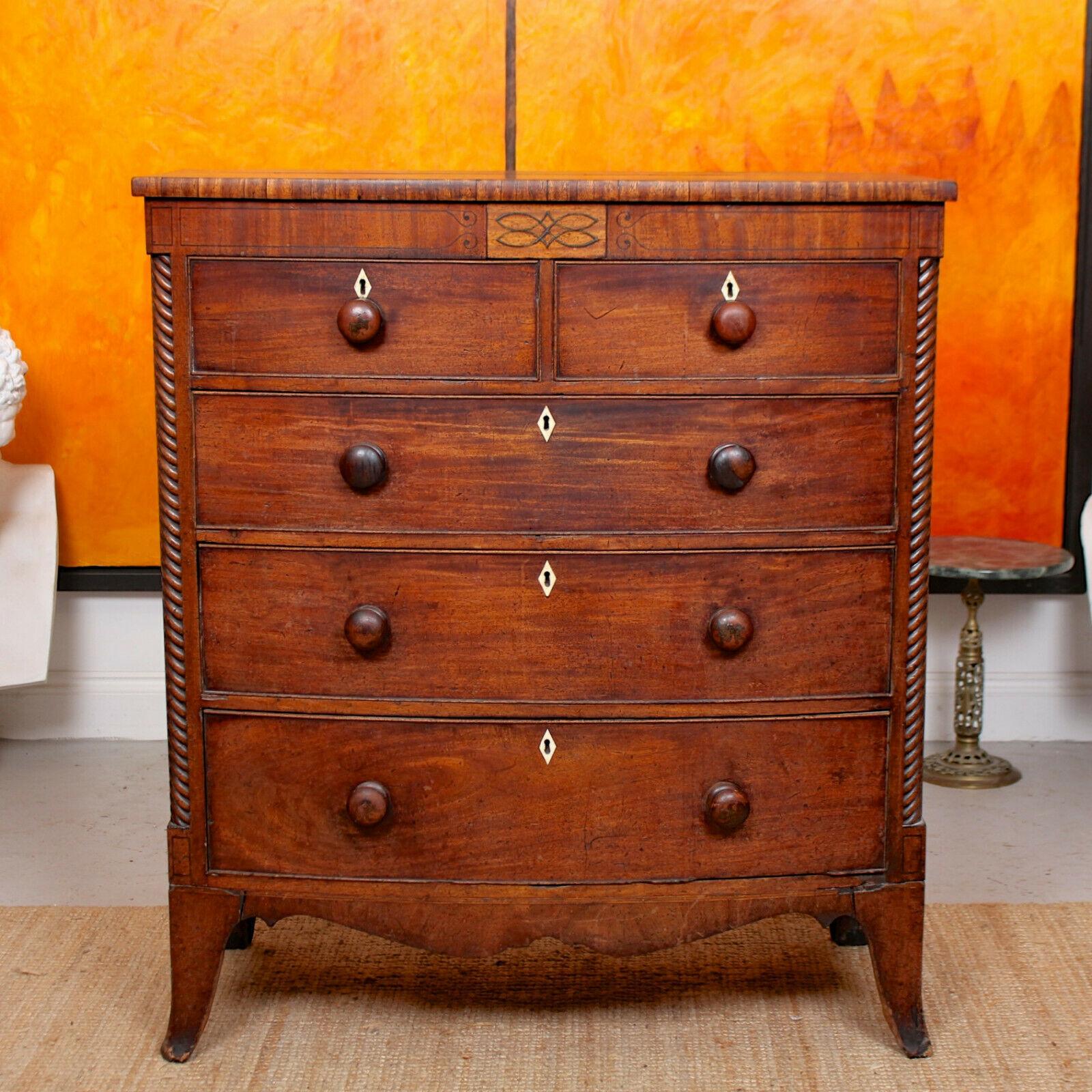 A stunning mid-19th century mahogany bowfront chest of drawers.

Excellent inlay work to the shaped frieze above two short and three long bowfront drawers mounted with good handles, plank interiors, dovetailed jointing and flanked by carved