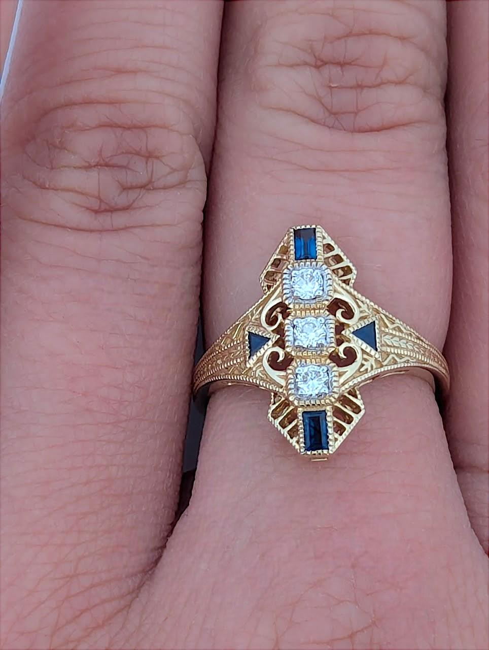 Este impresionante anillo de oro amarillo de 14k presenta una hermosa combinación de brillantes diamantes y ricos zafiros azules. Con diamantes de 0,15 quilates y zafiros de 0,25 quilates, este anillo está diseñado para impresionar por su elegancia